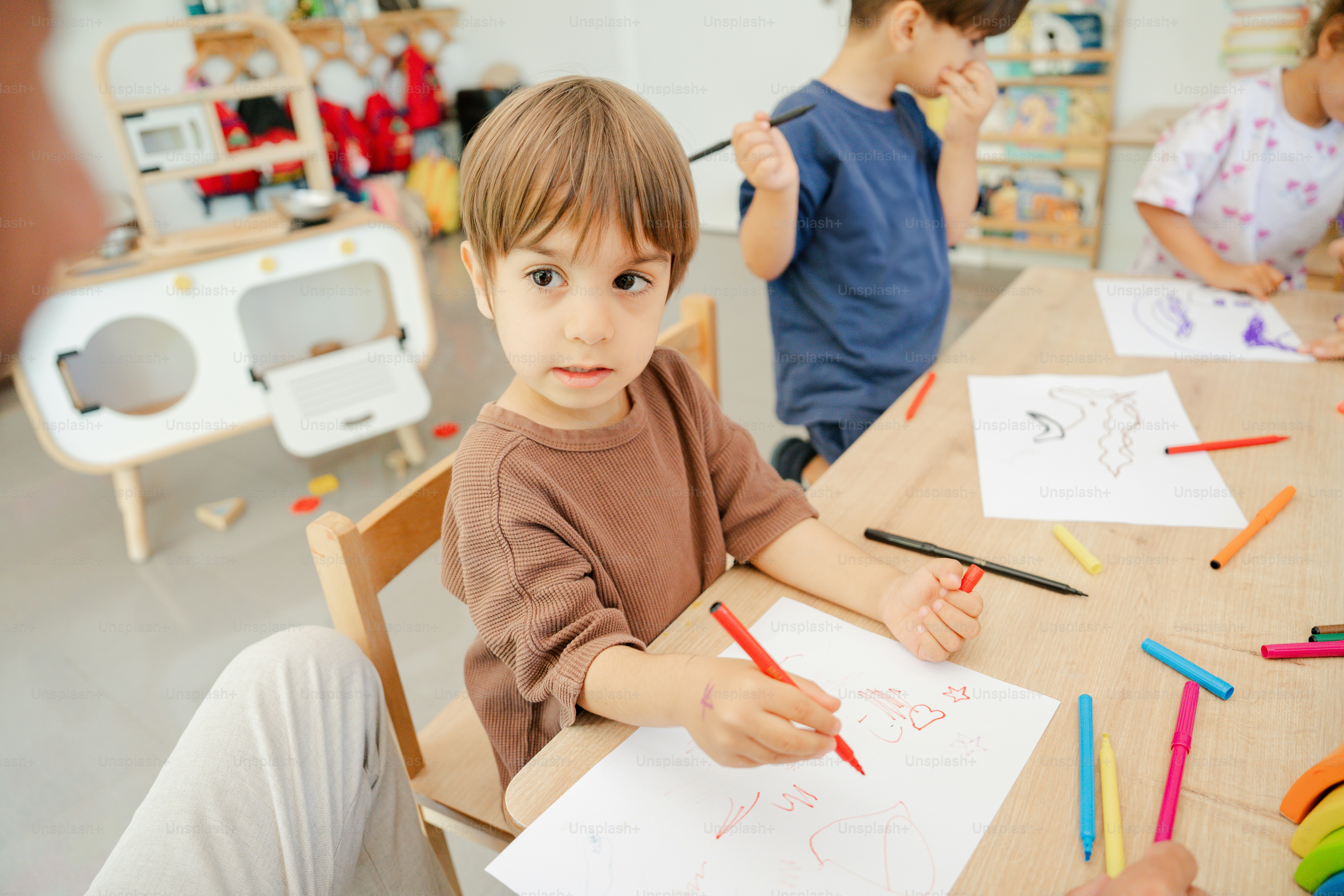 Children play with blocks while a teacher supervises. photo – Kids ...