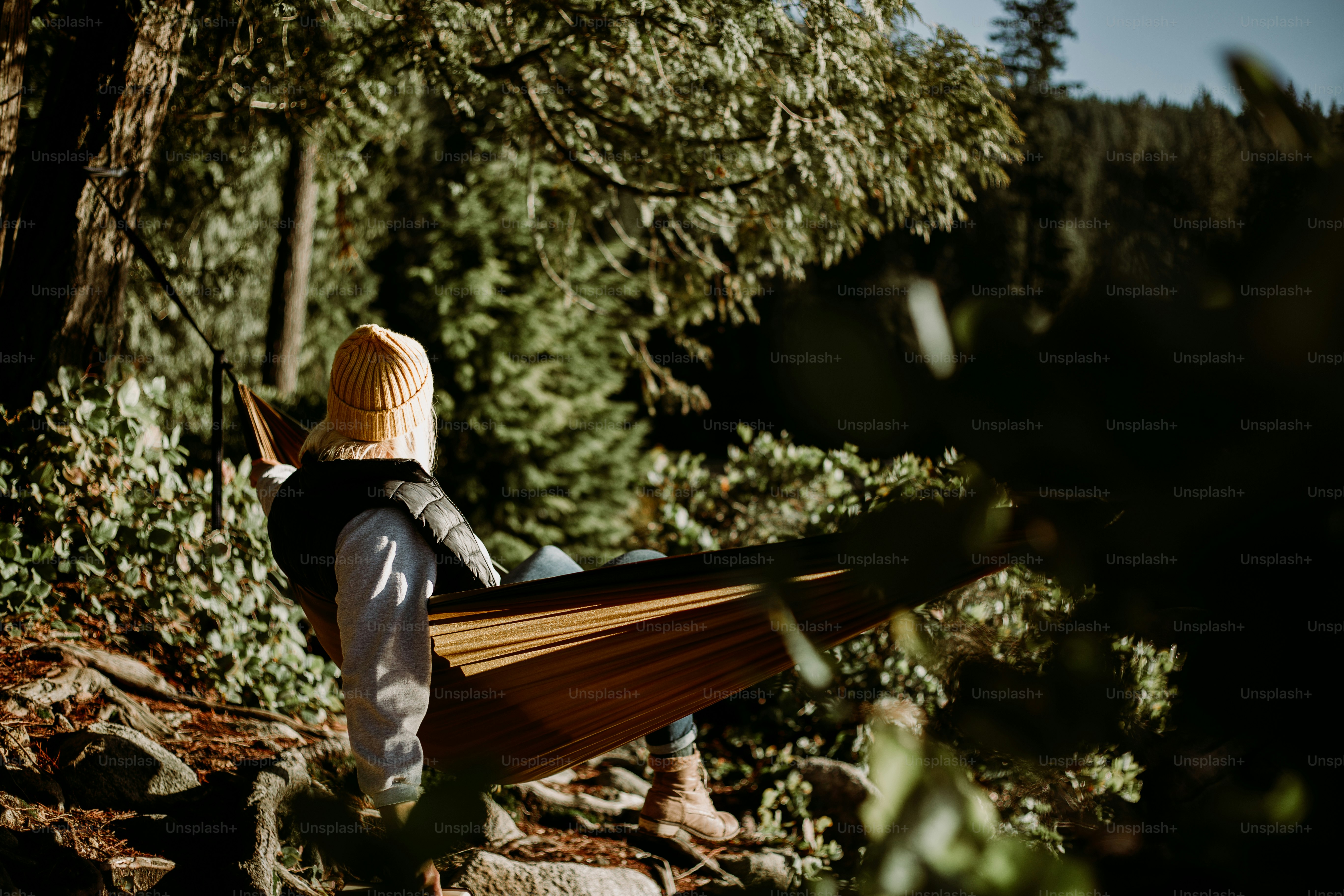 A person relaxes in a hammock outdoors.