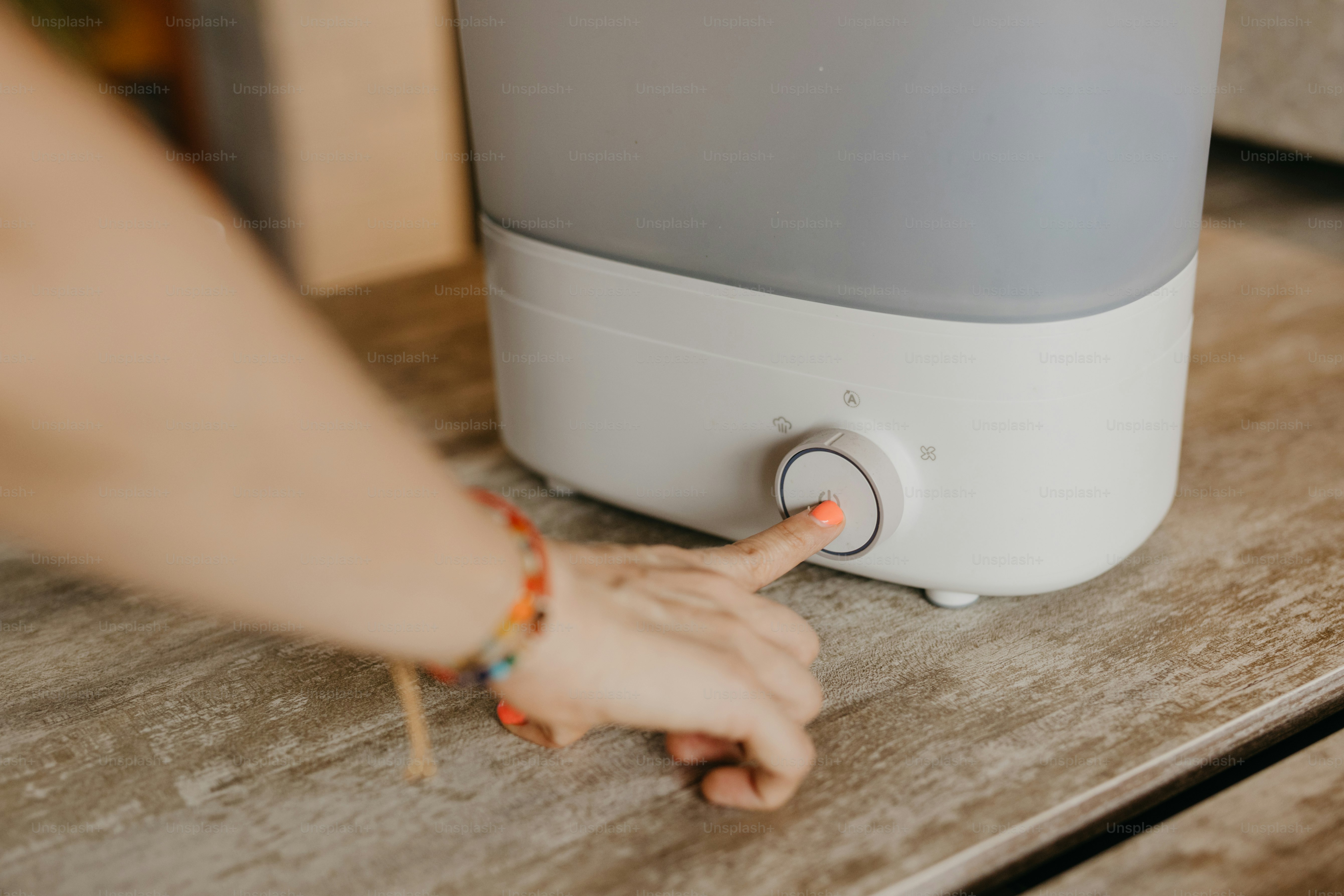 A hand is turning on a device's control.