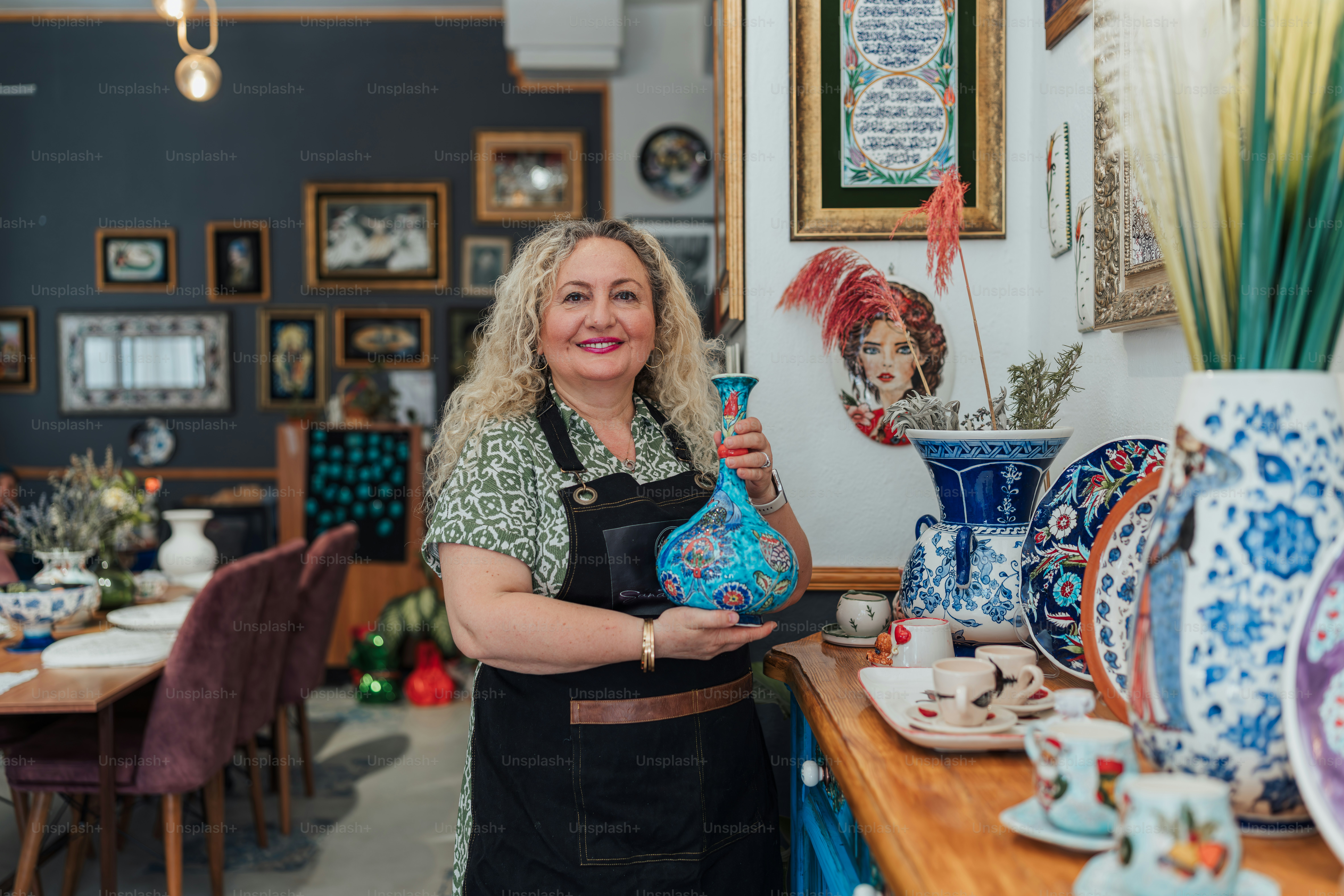 A smiling woman poses in a pottery shop. photo – Business Image on Unsplash