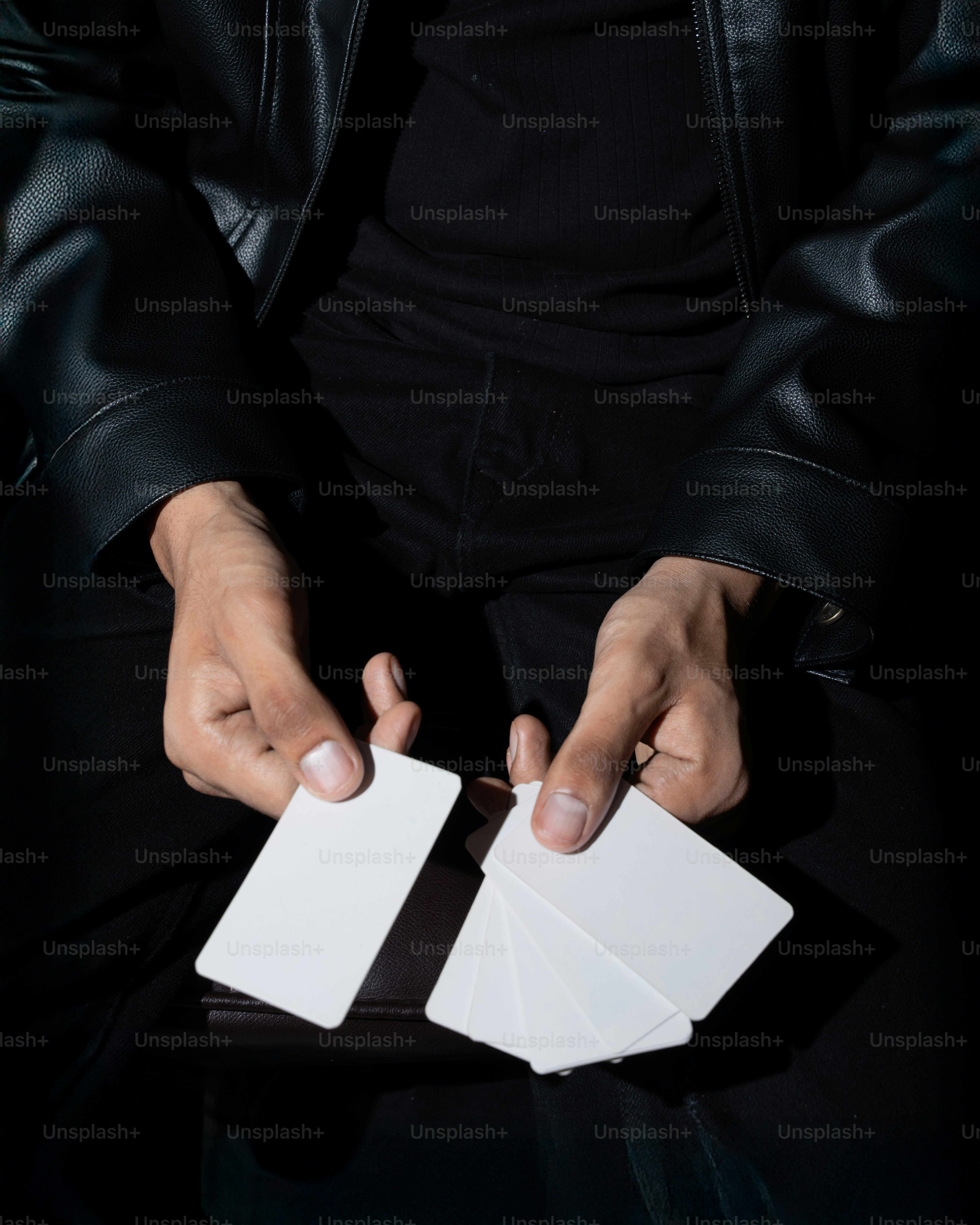 La persona sostiene varias cartas en blanco.