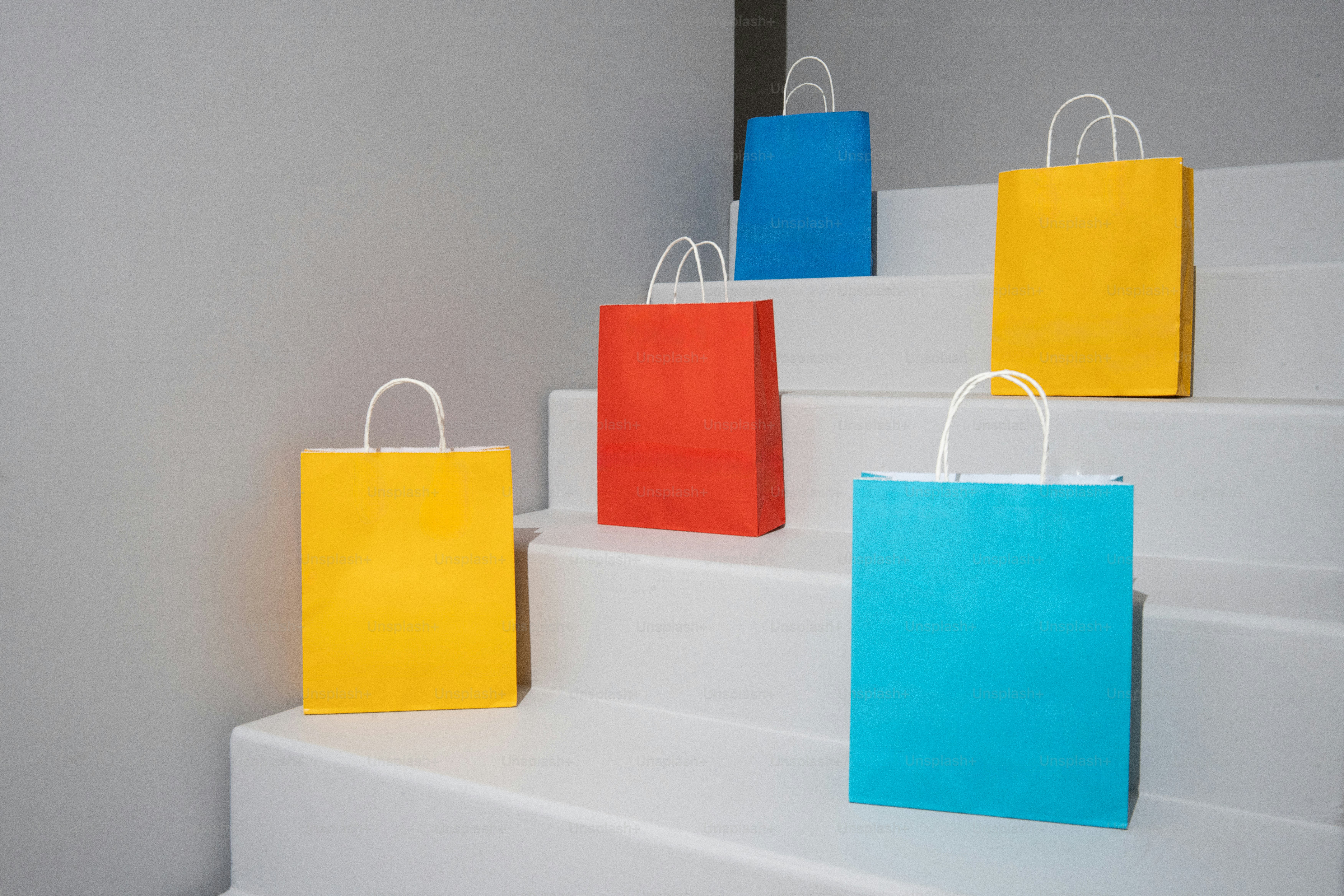 Colorful shopping bags rest on white stairs.