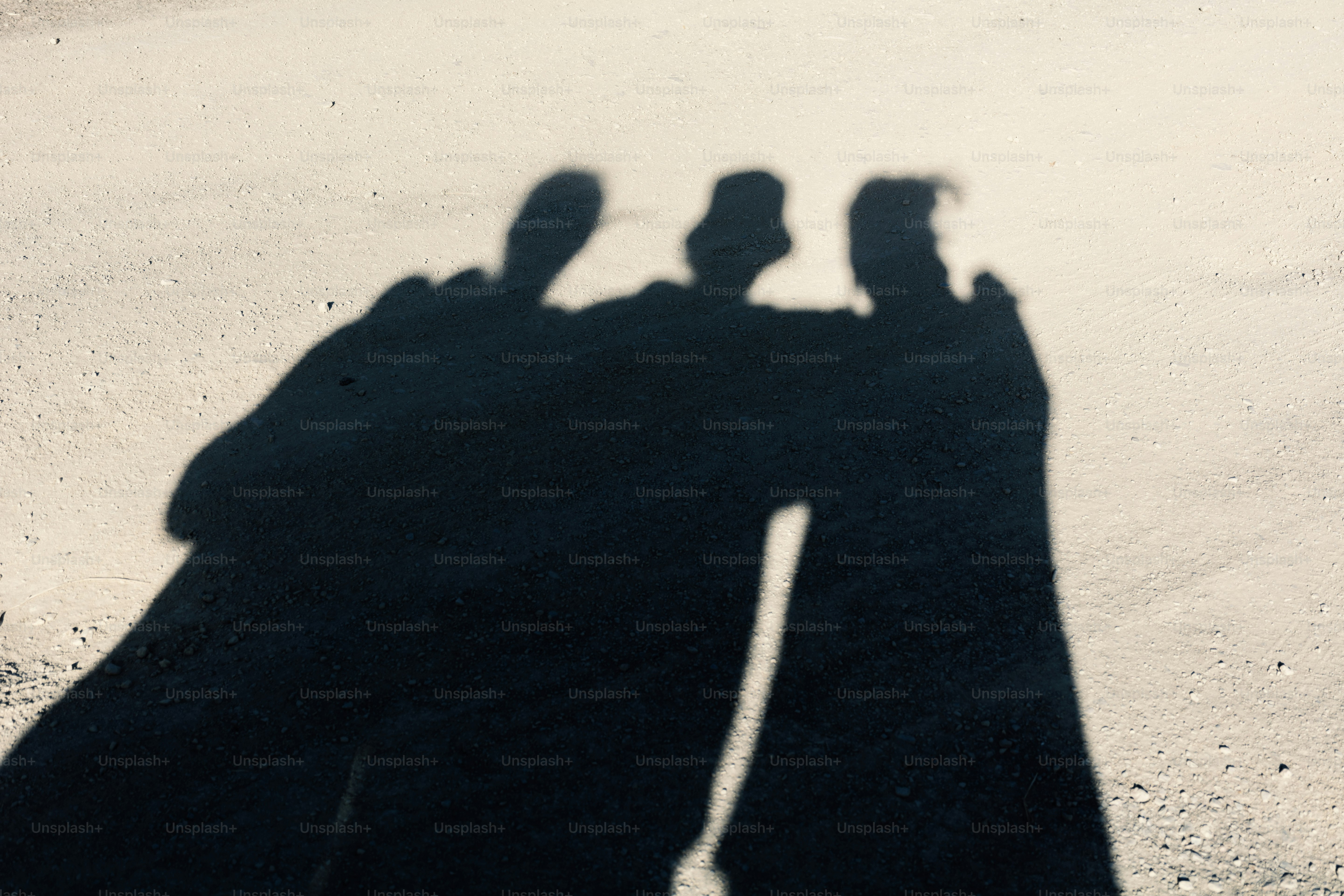 Die Schatten von drei Personen werden auf eine Oberfläche geworfen.