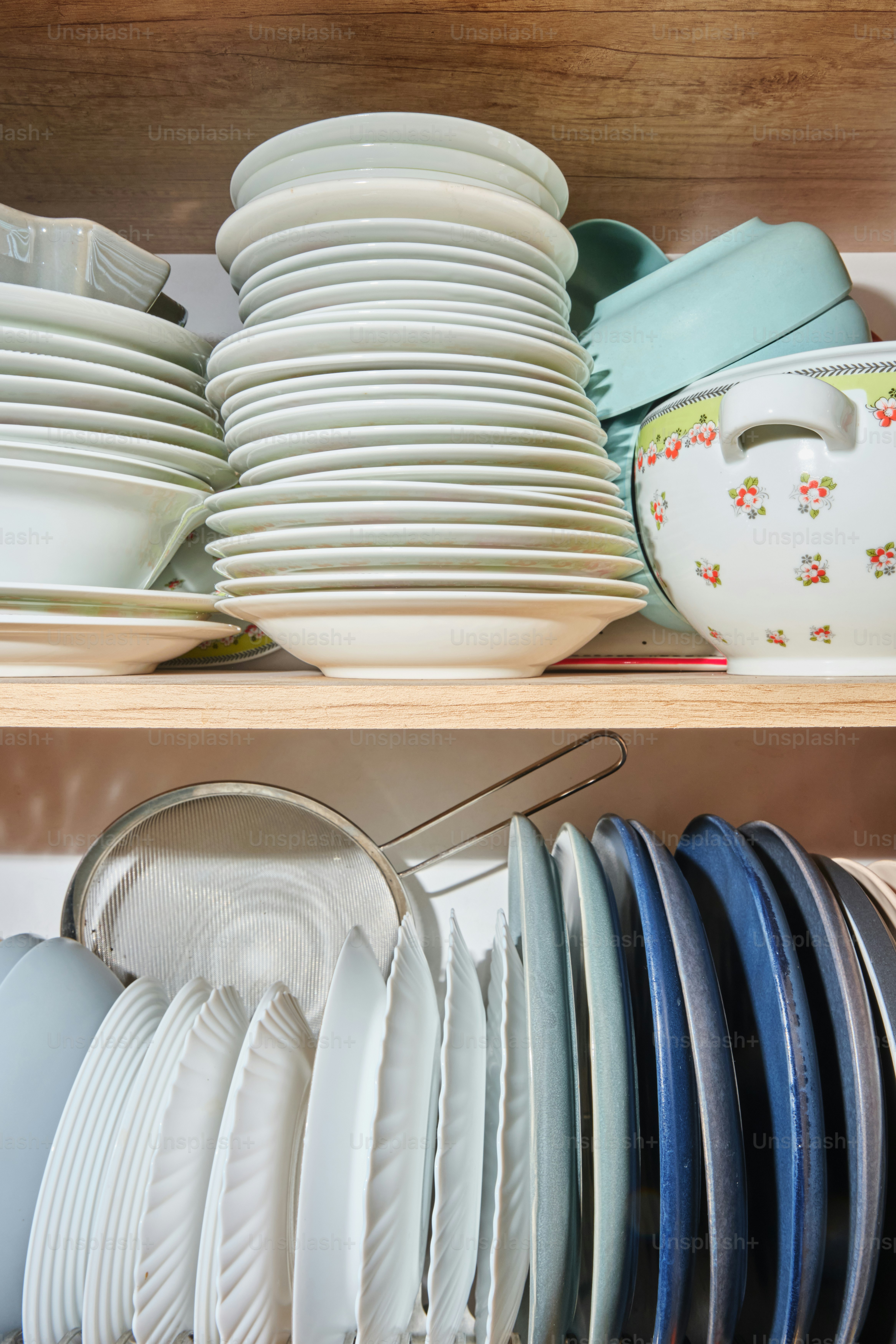 Dishes neatly stacked inside a kitchen cabinet.