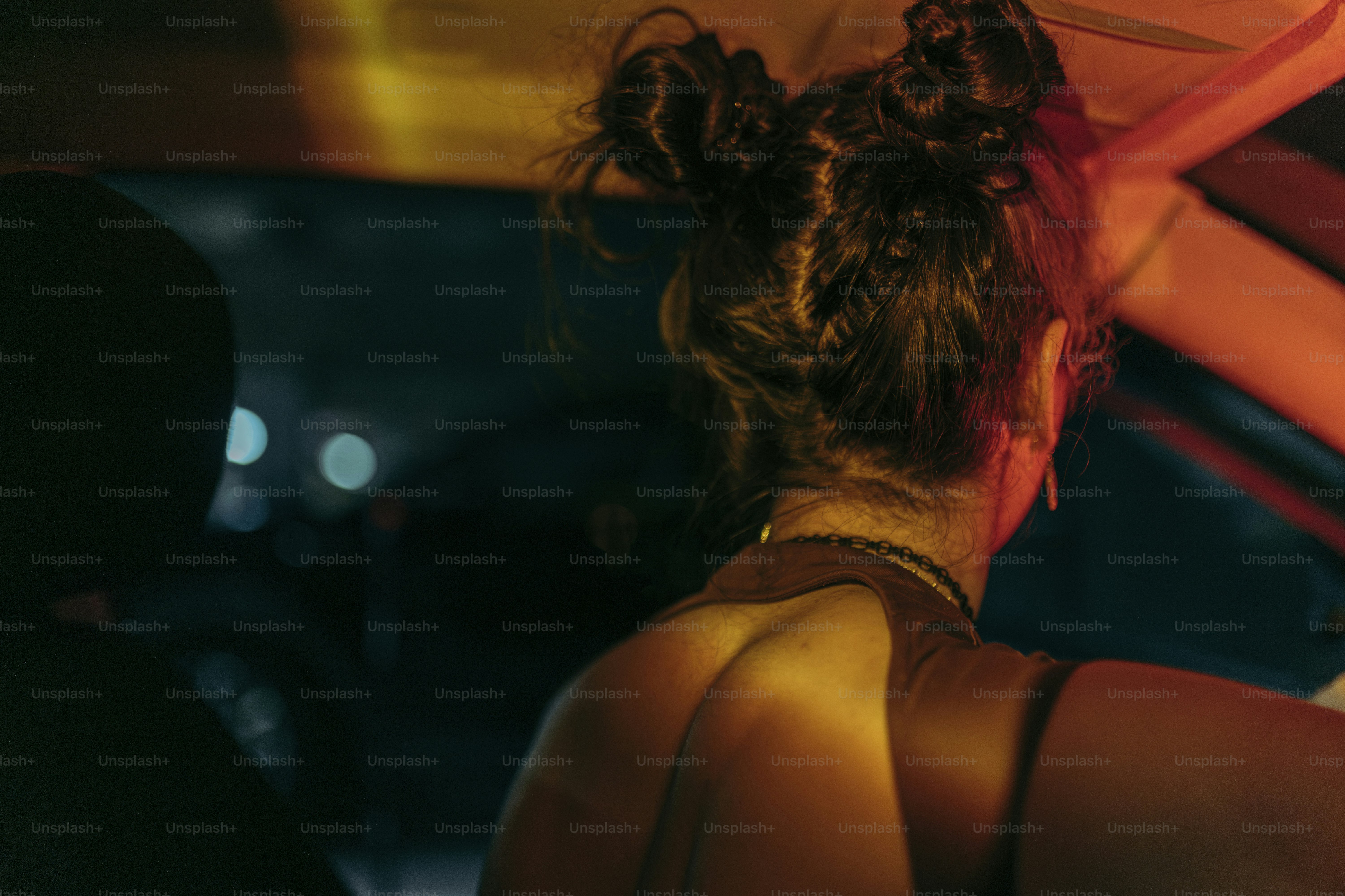 La nuit, une femme regarde par la fenêtre d’une voiture.