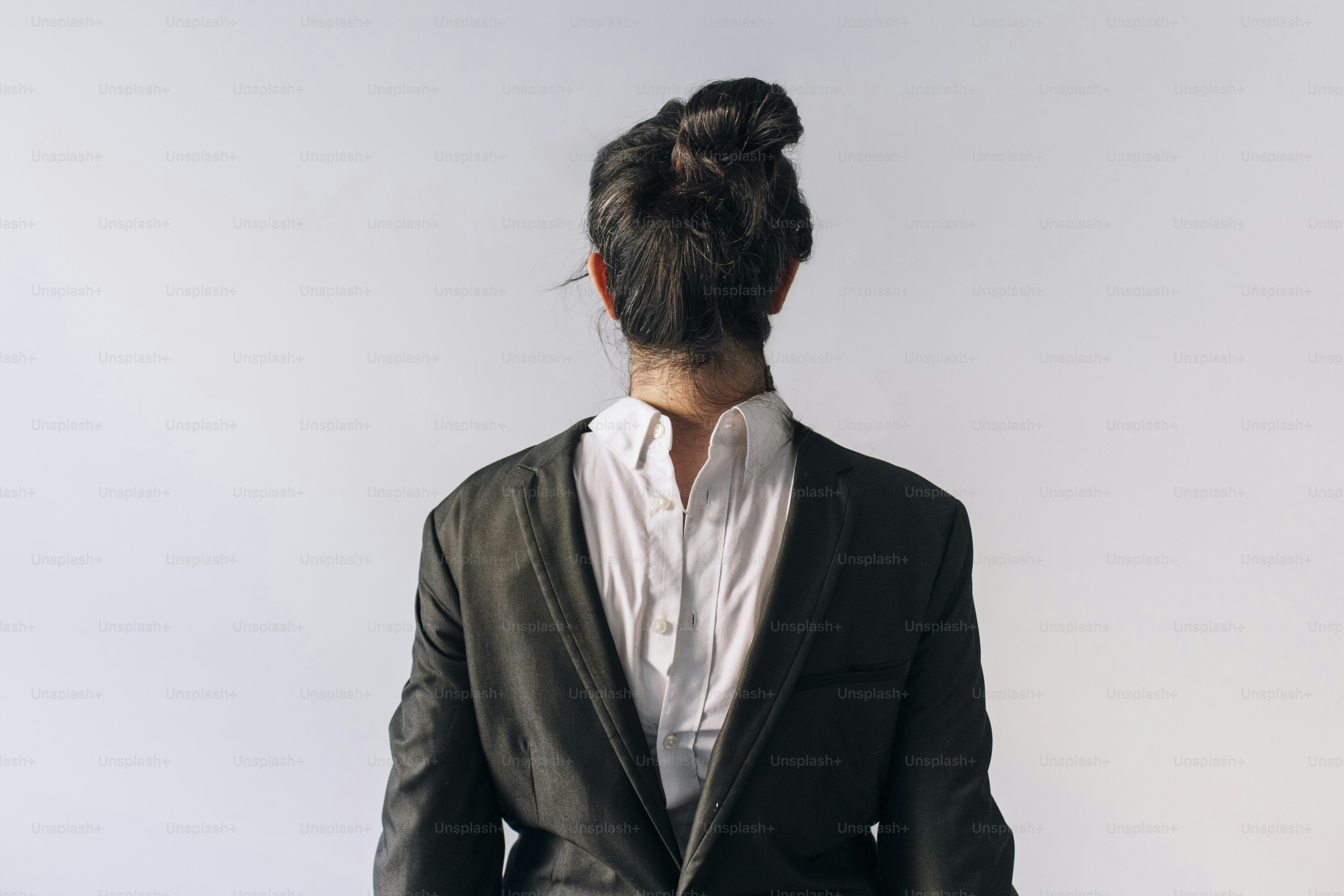 La femme en costume est vue de dos.