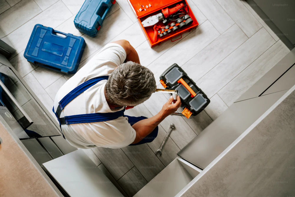 Maintenance professional working with tools inside a property