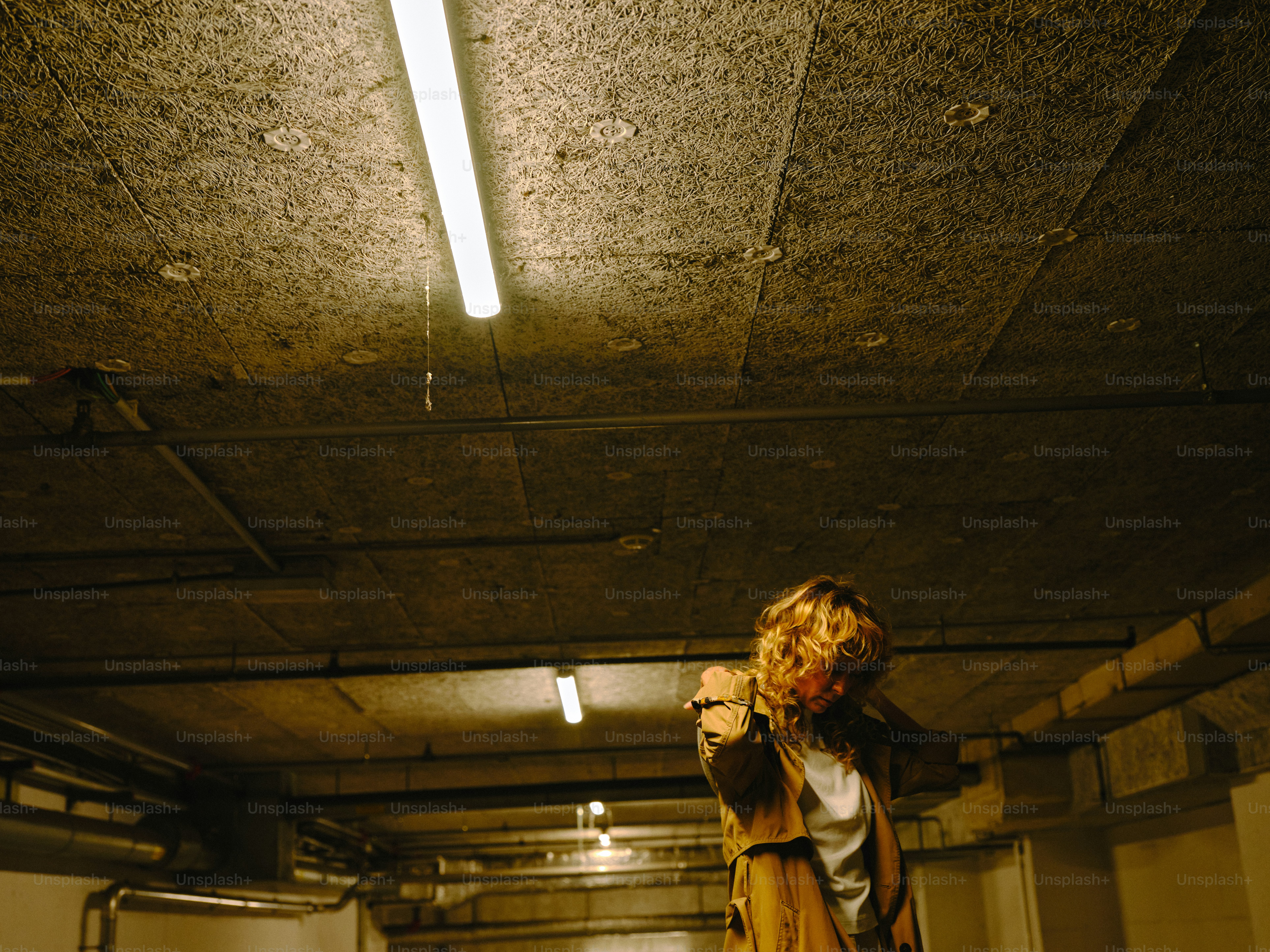 A person points a gun in a dark, grungy space.