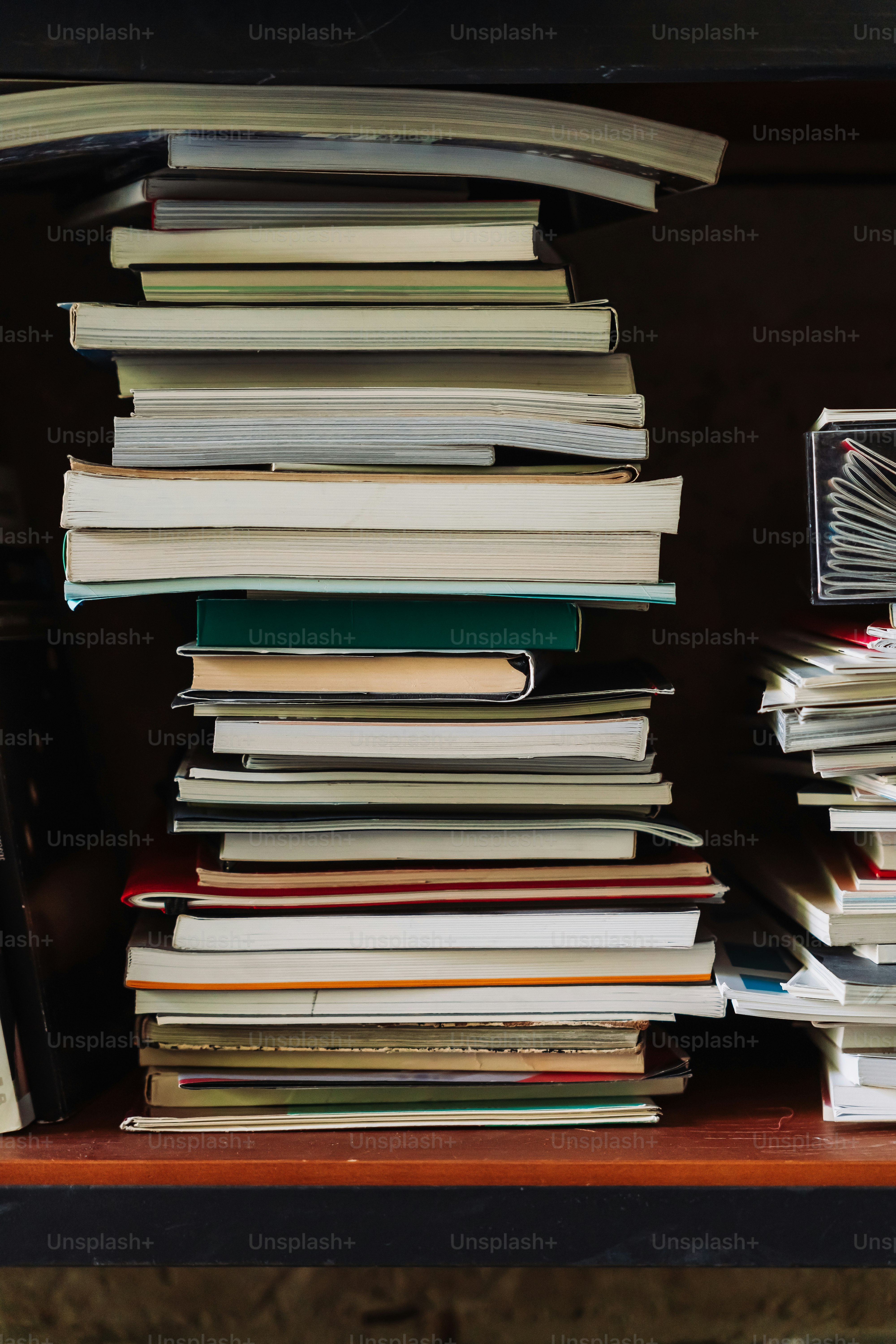 Ein Stapel Bücher steht auf einem Regal.