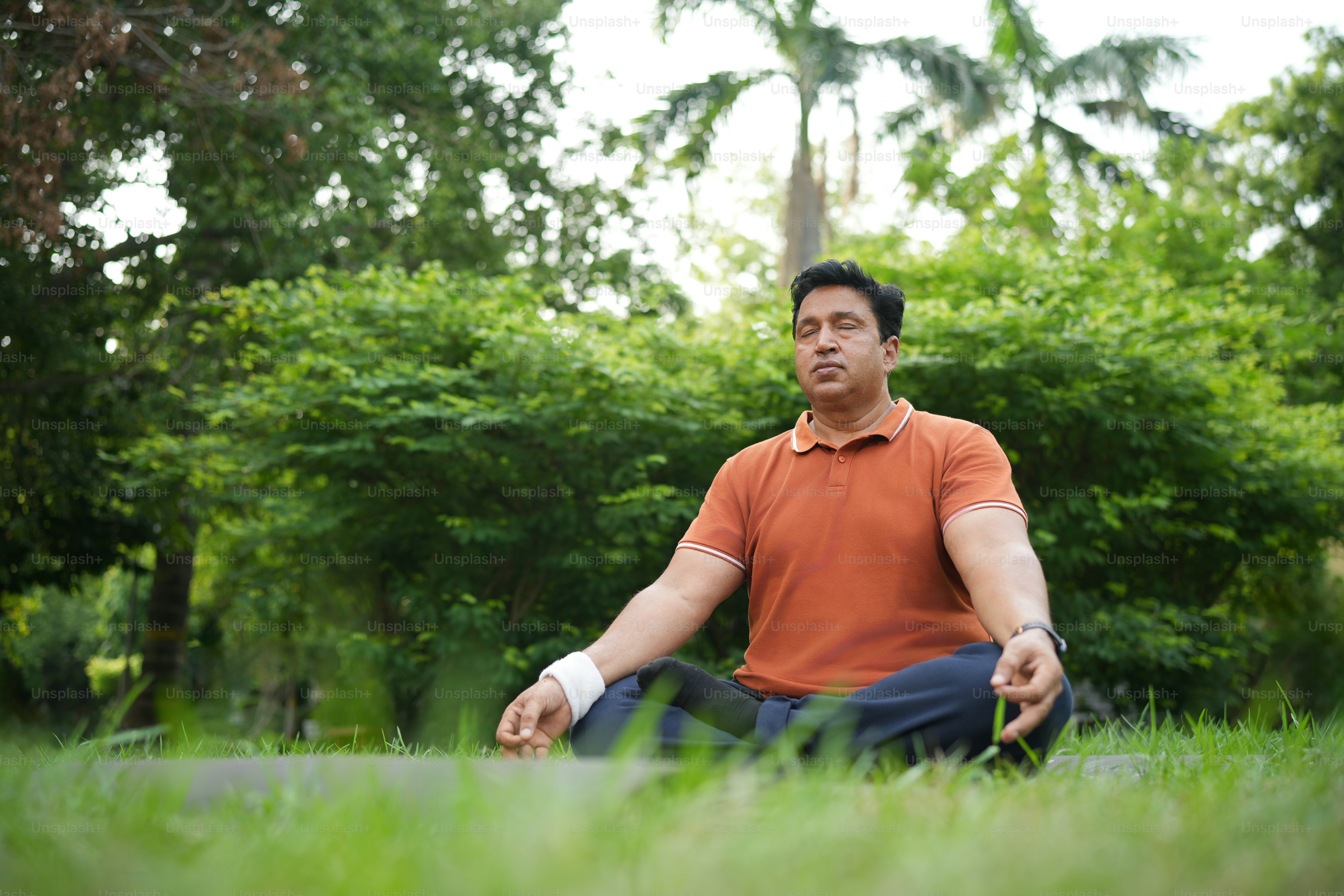 Un uomo sta meditando all'aperto in un parco.