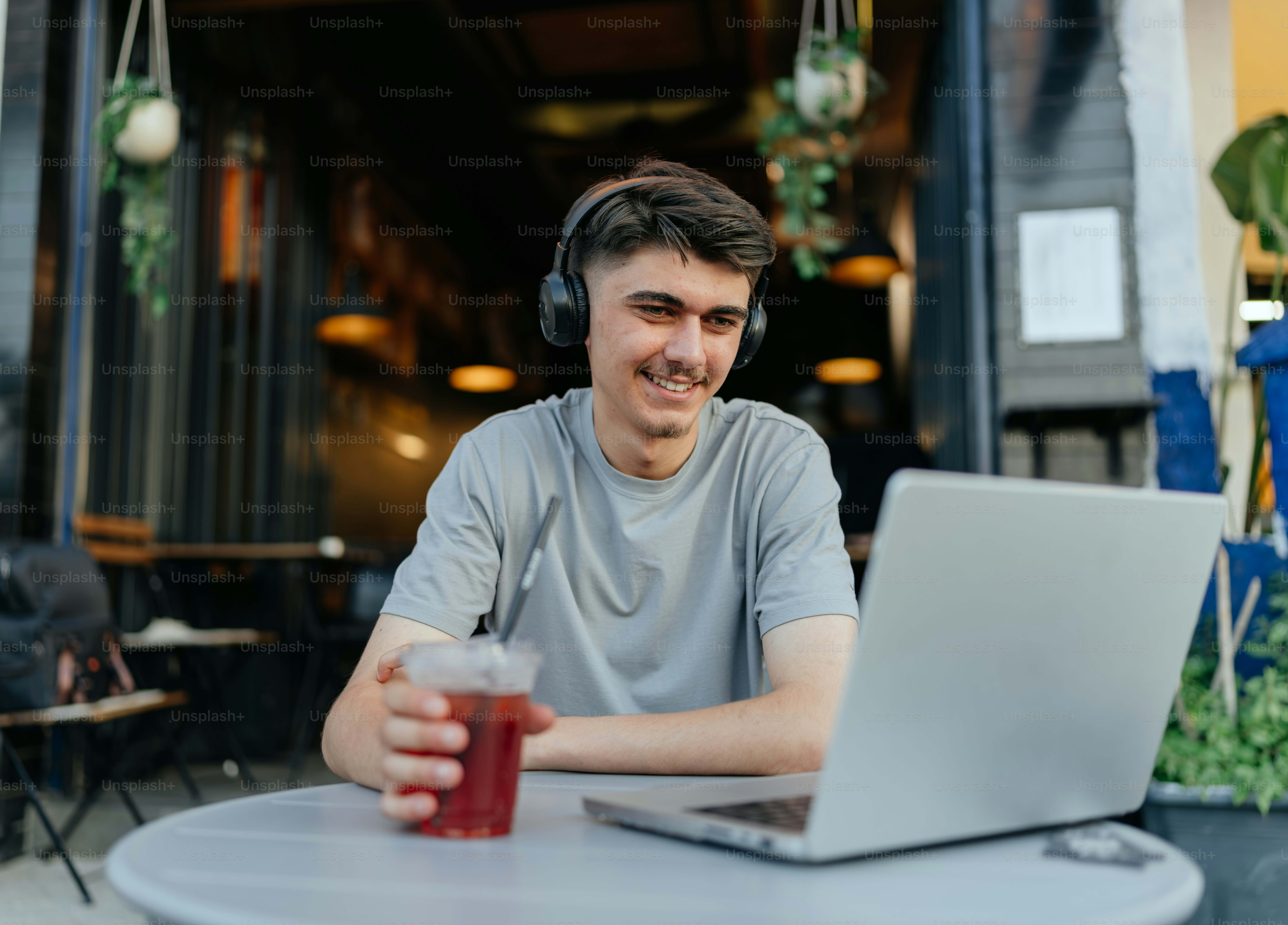 A man works on a laptop while at a cafe.