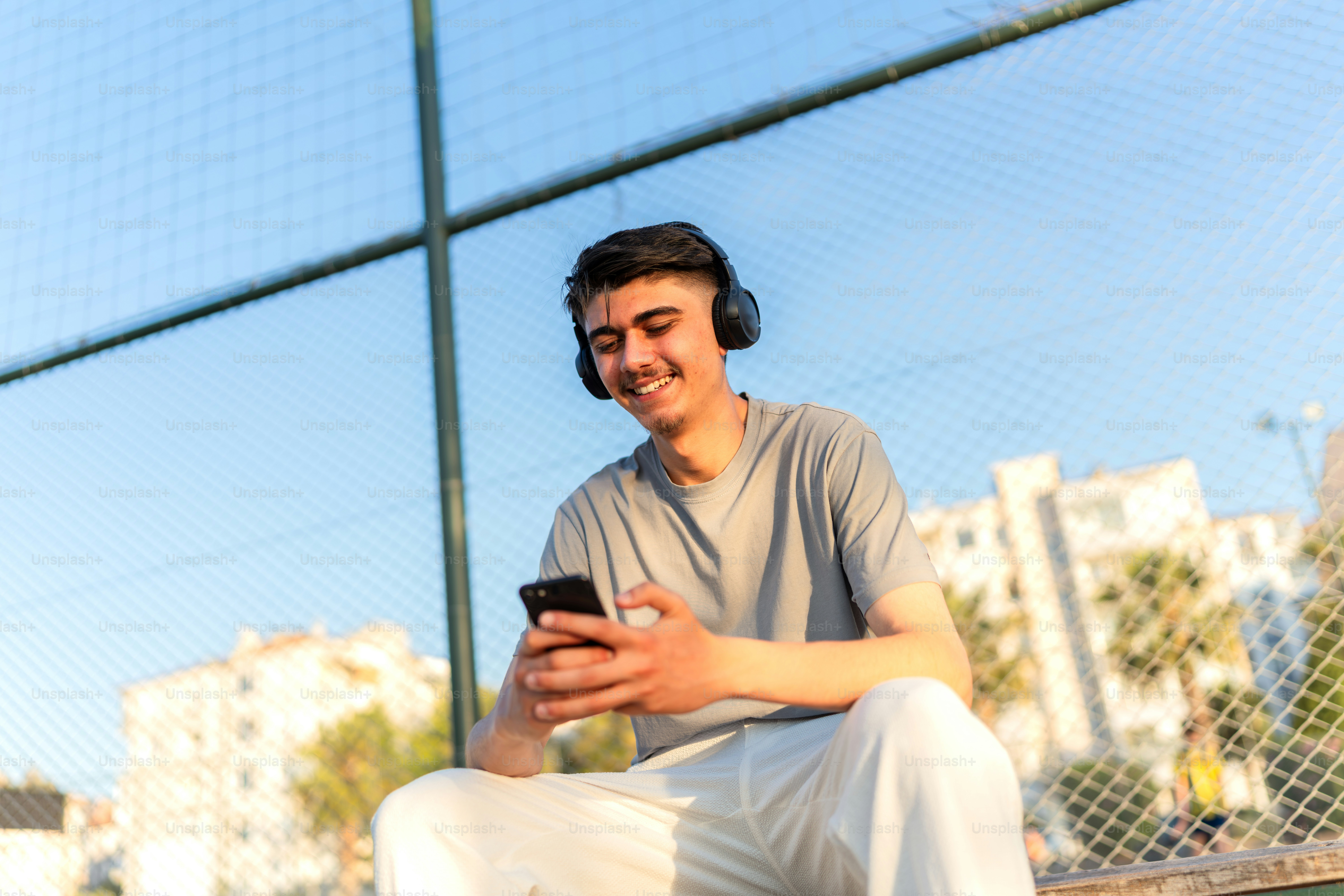 A young man listens to music and smiles.