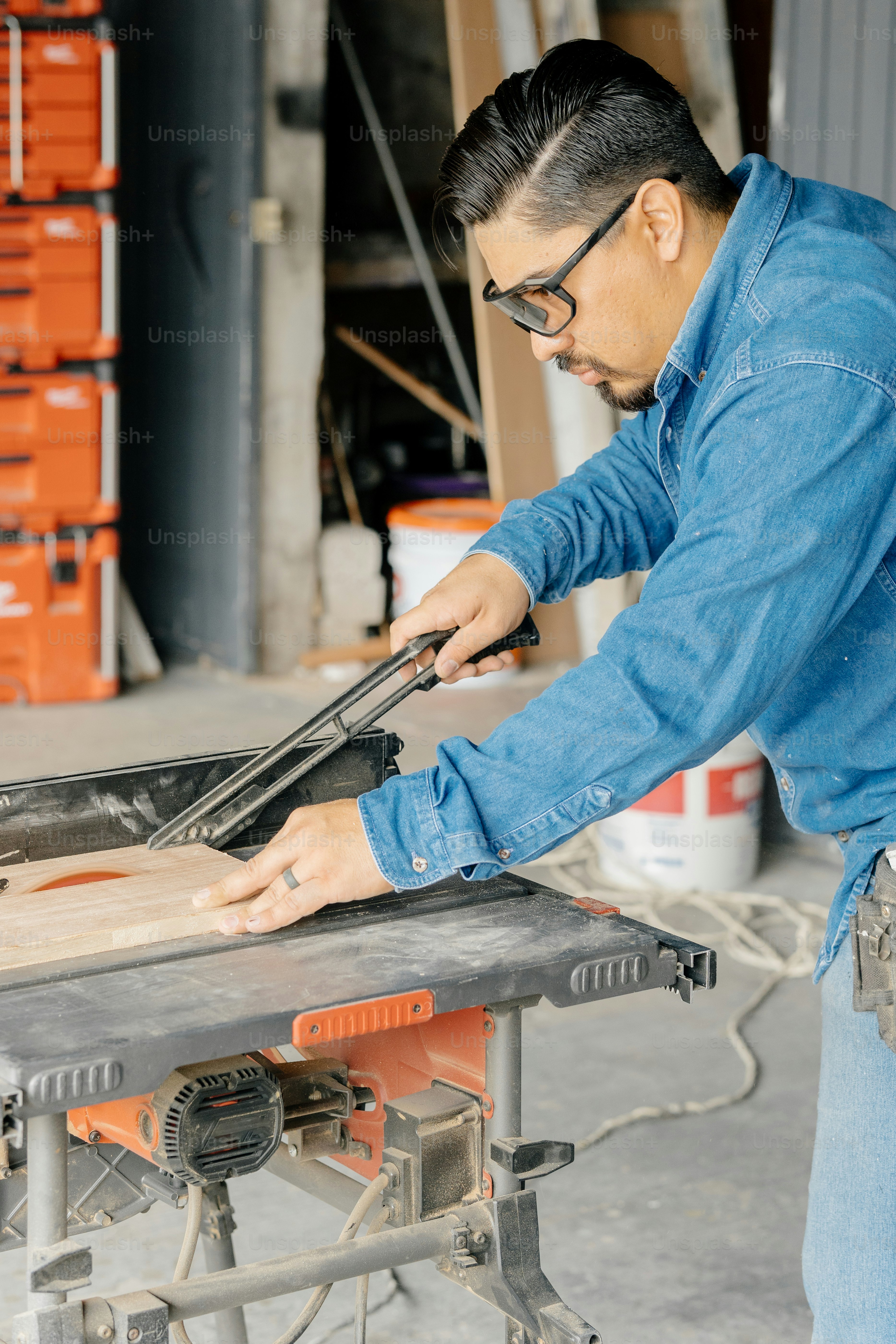 Un charpentier utilise une scie pour couper un morceau de bois.