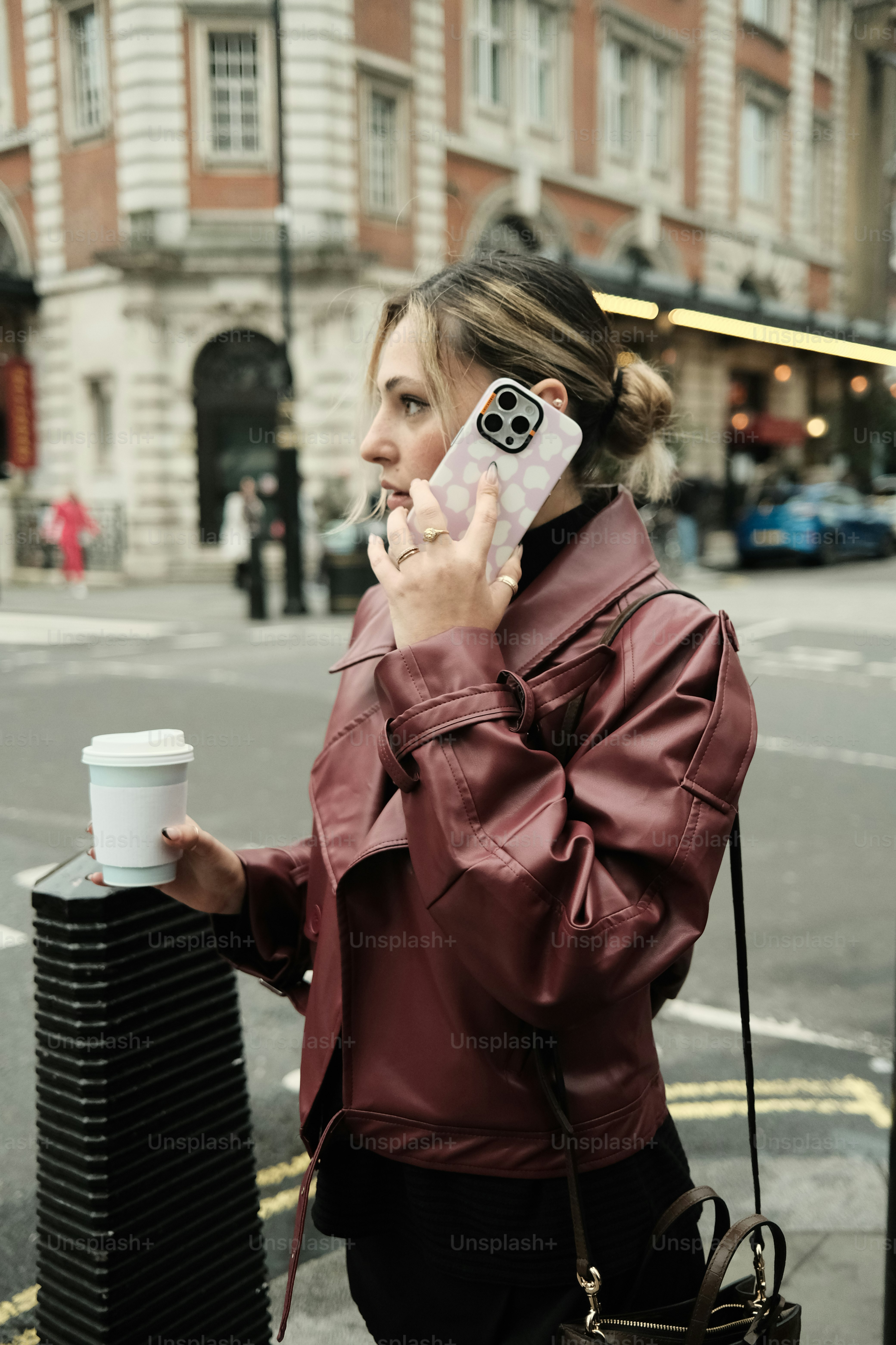 Woman talks on her phone while holding coffee.