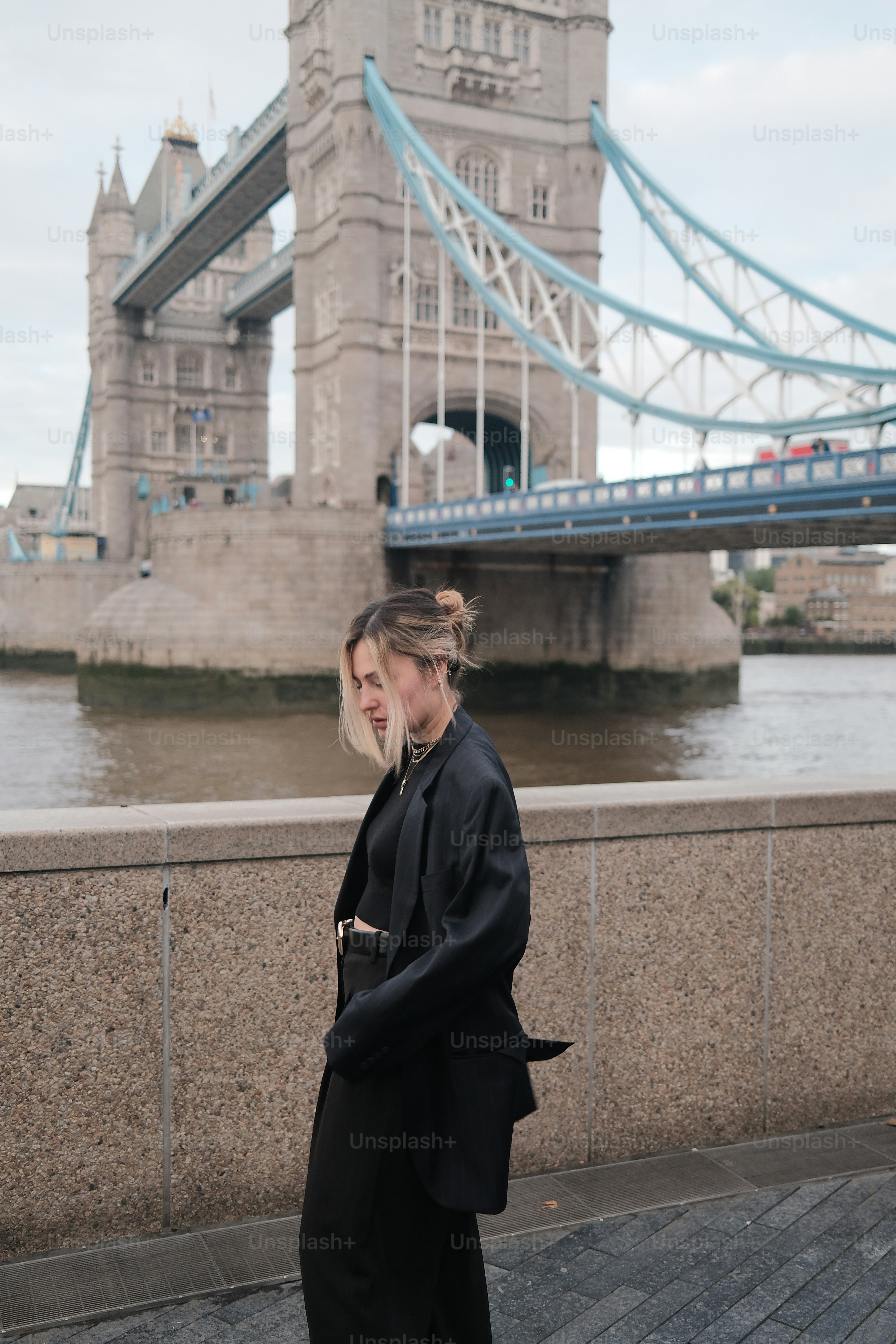 Woman poses in front of the tower bridge.