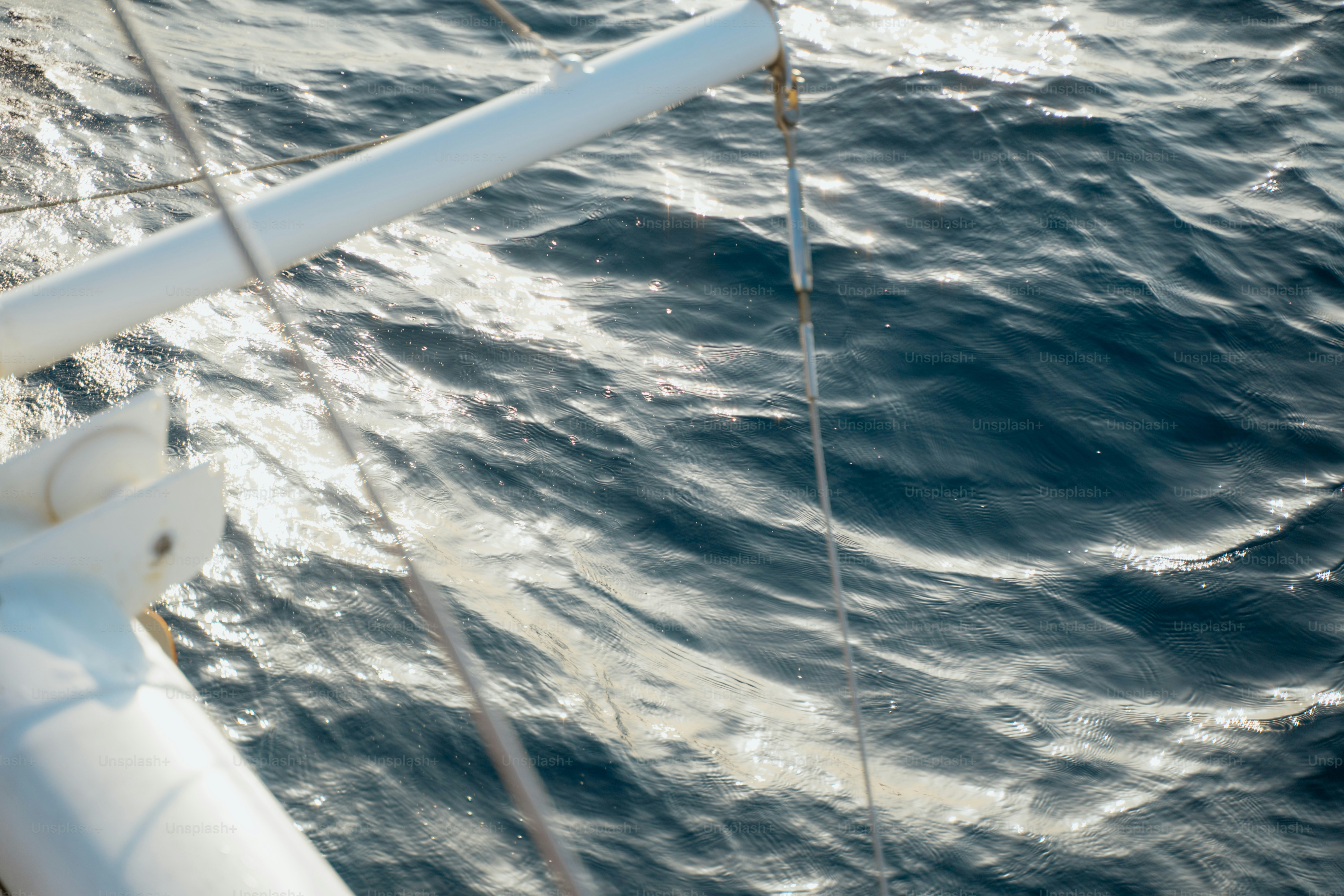 A boat's mast overlooking choppy, blue water.