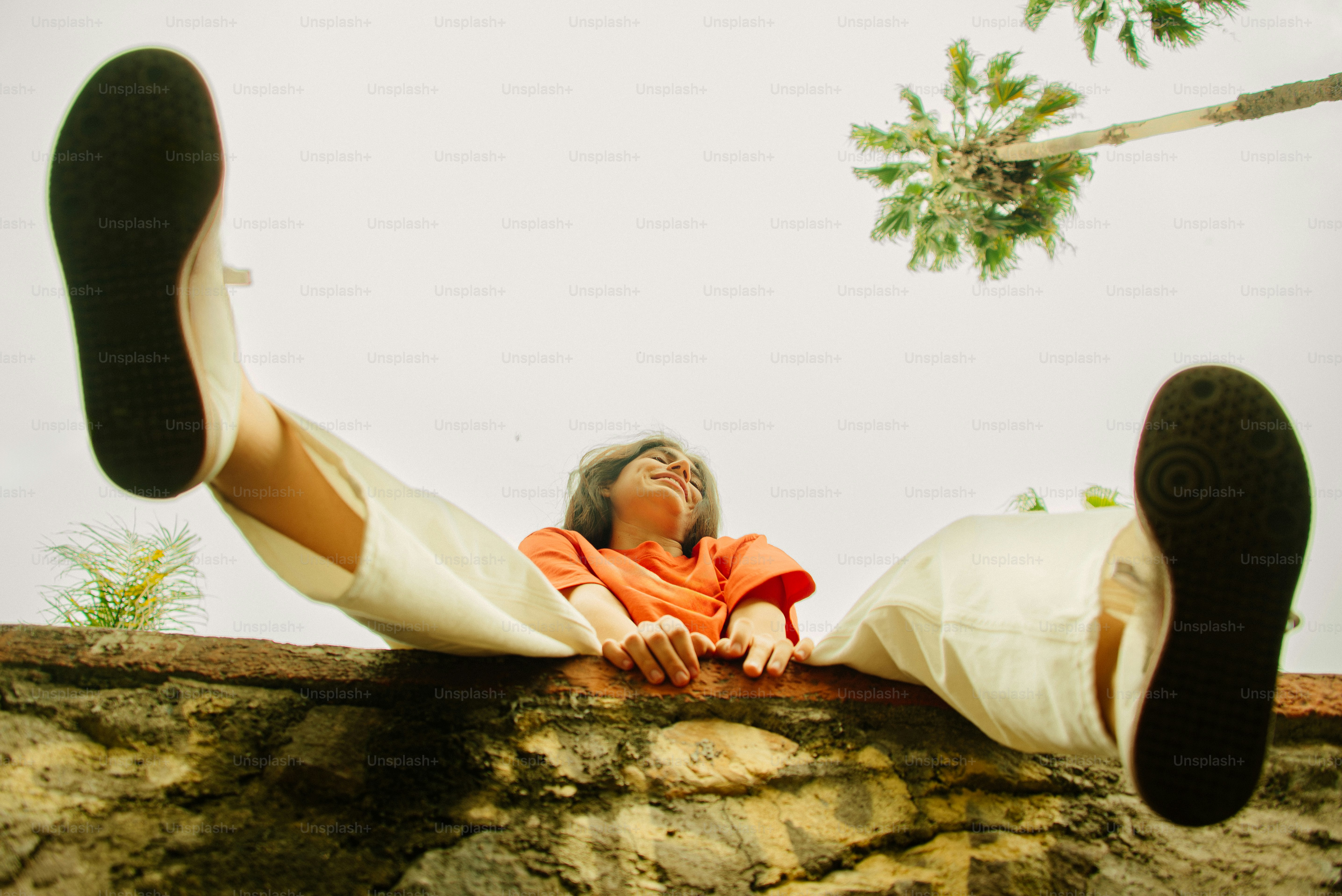 Woman relaxes and stretches her legs on a wall.