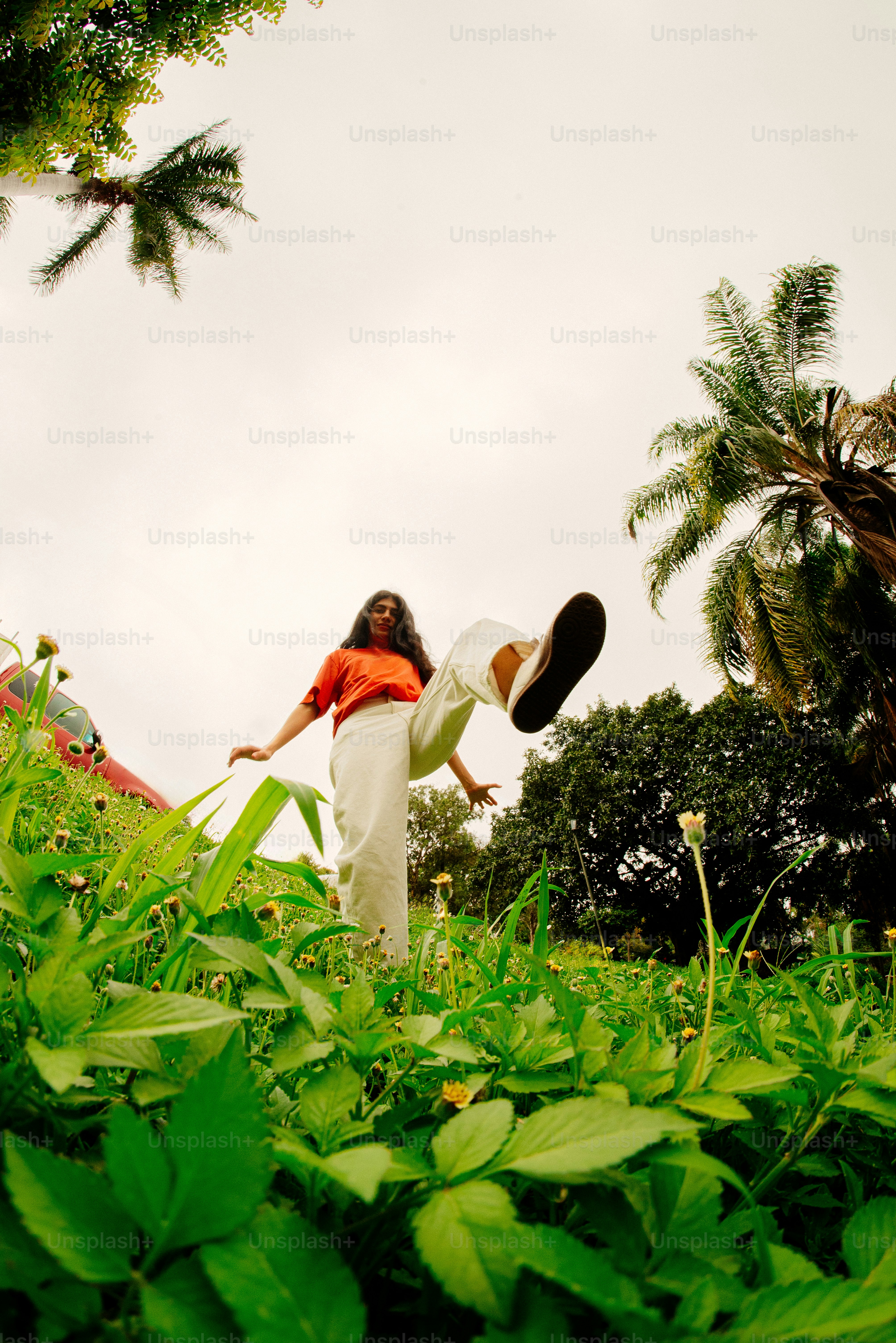 Woman jumps in a grassy, green field.