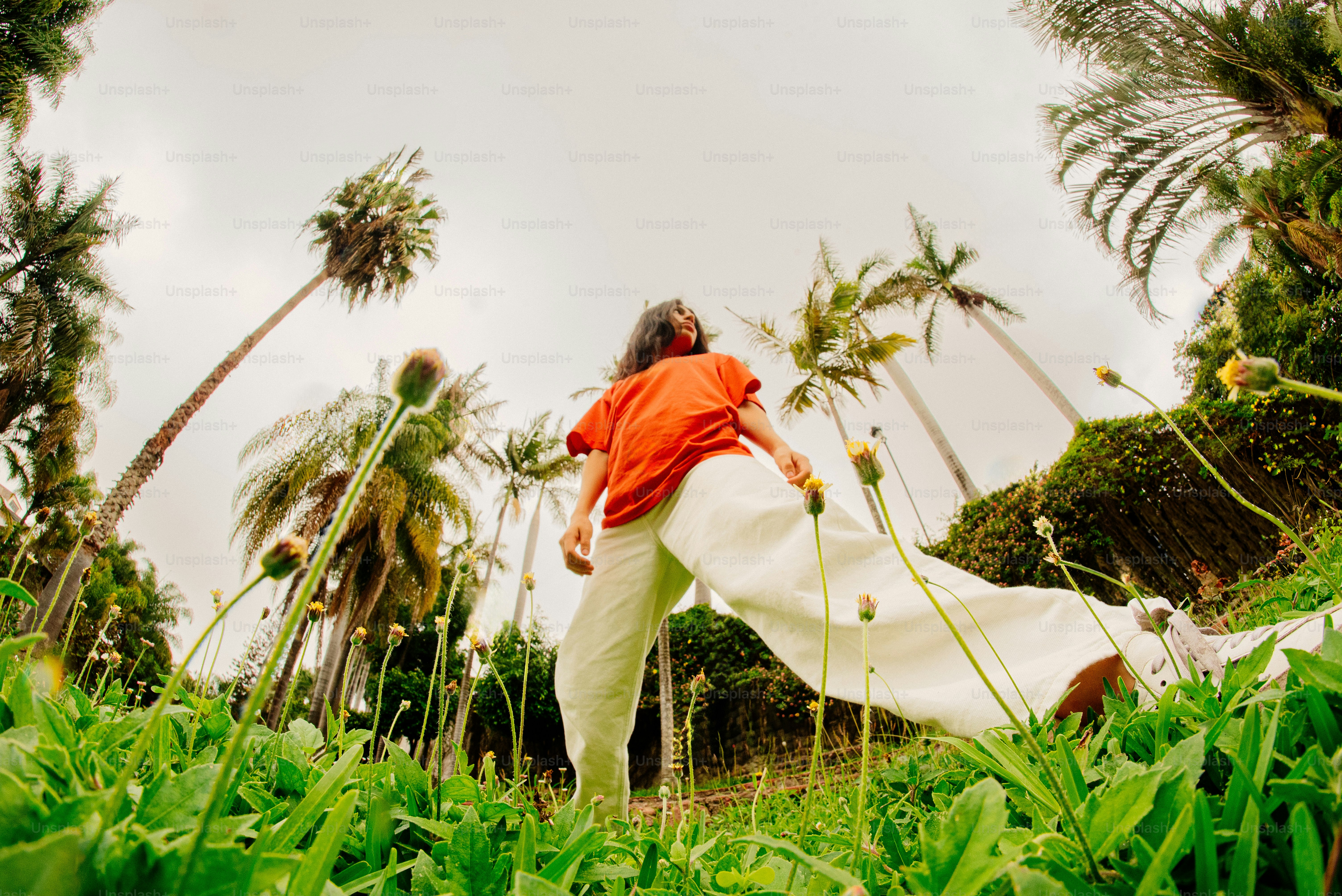 Femme dans un champ avec des palmiers.