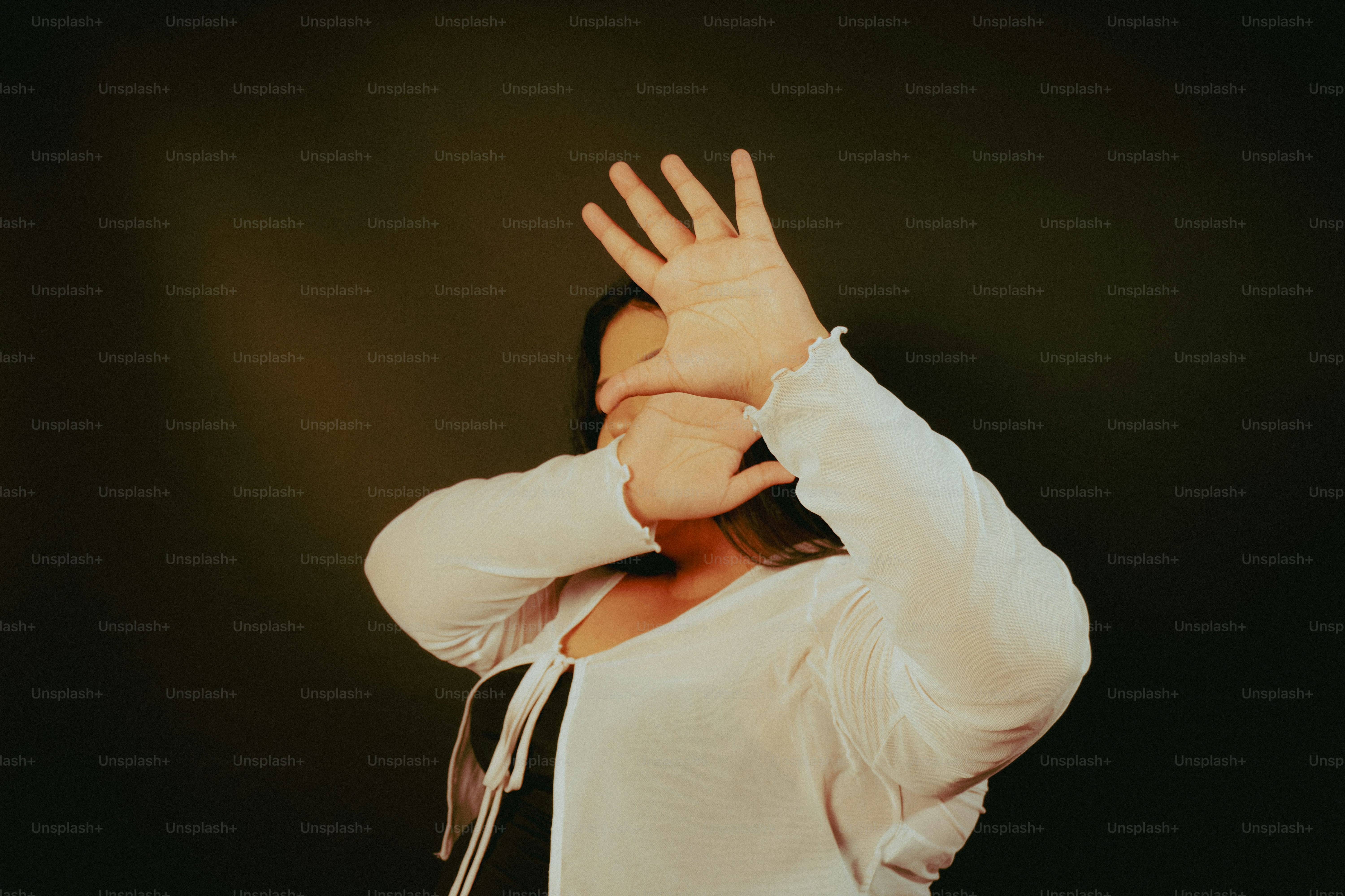 Person raises hands in front of face.