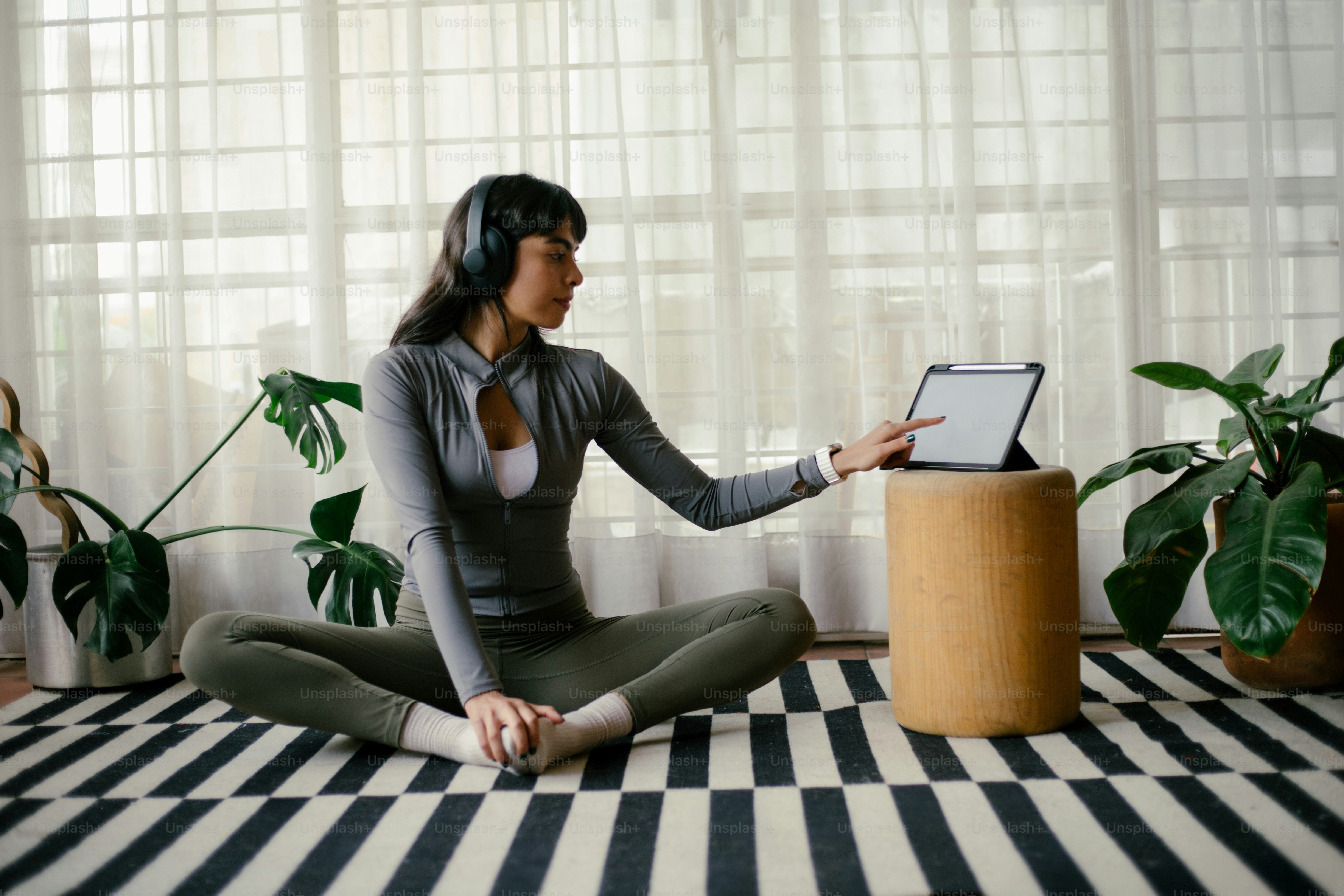 Woman uses a tablet during a yoga session.