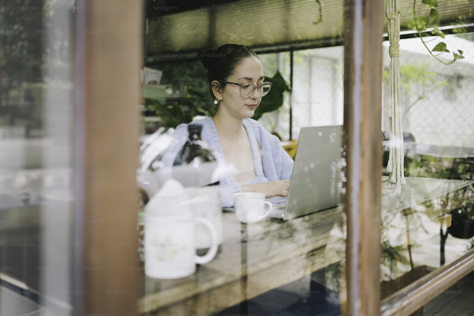 Stylish home-office scene with a laptop open to revenue graphs, a cup of coffee on the desk, and a soft countryside view through the window: a polished visual fit for a revenue and strategy-focused Cotswolds holiday let article.
