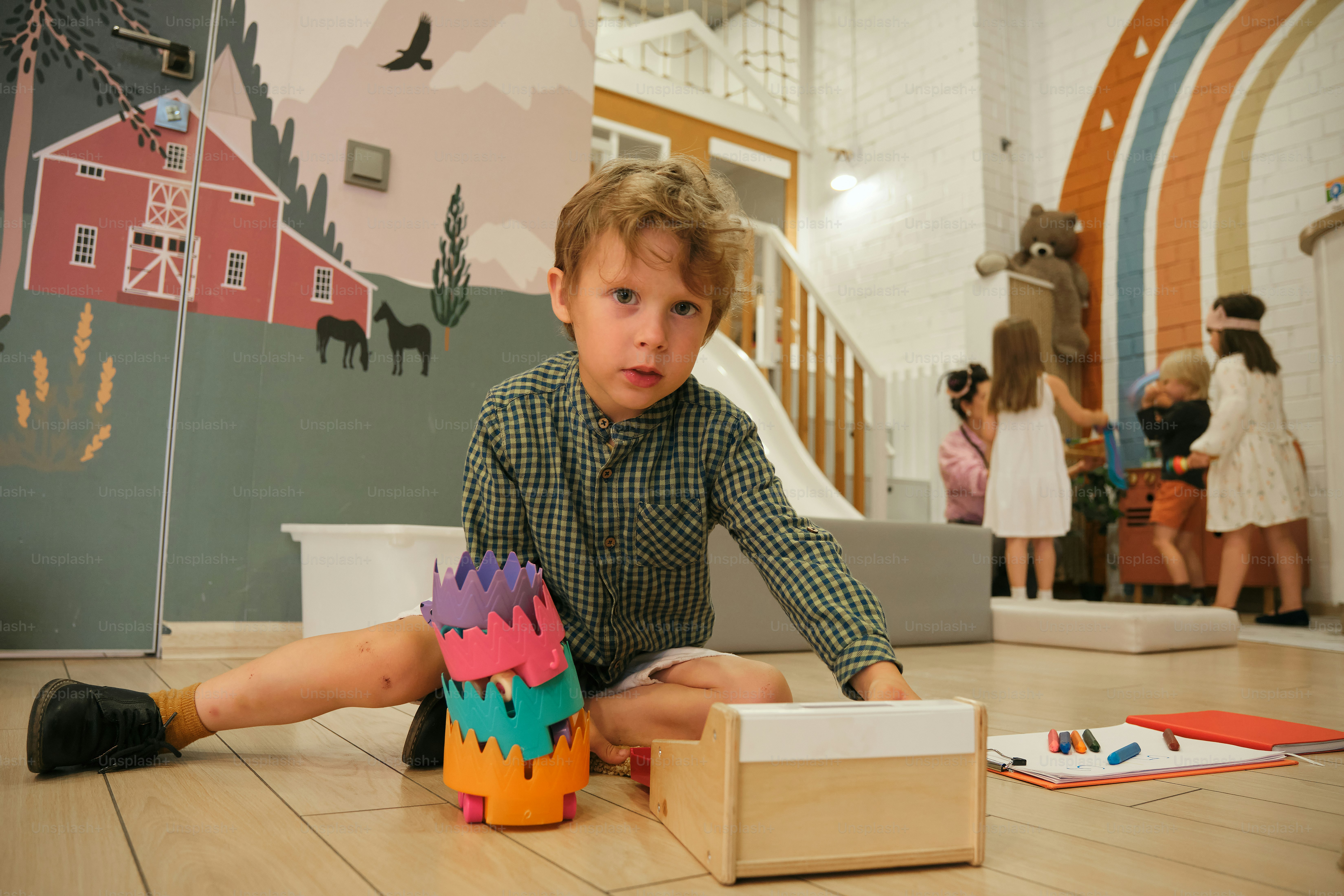 Ein Junge spielt in einem Spielzimmer mit Spielzeug.