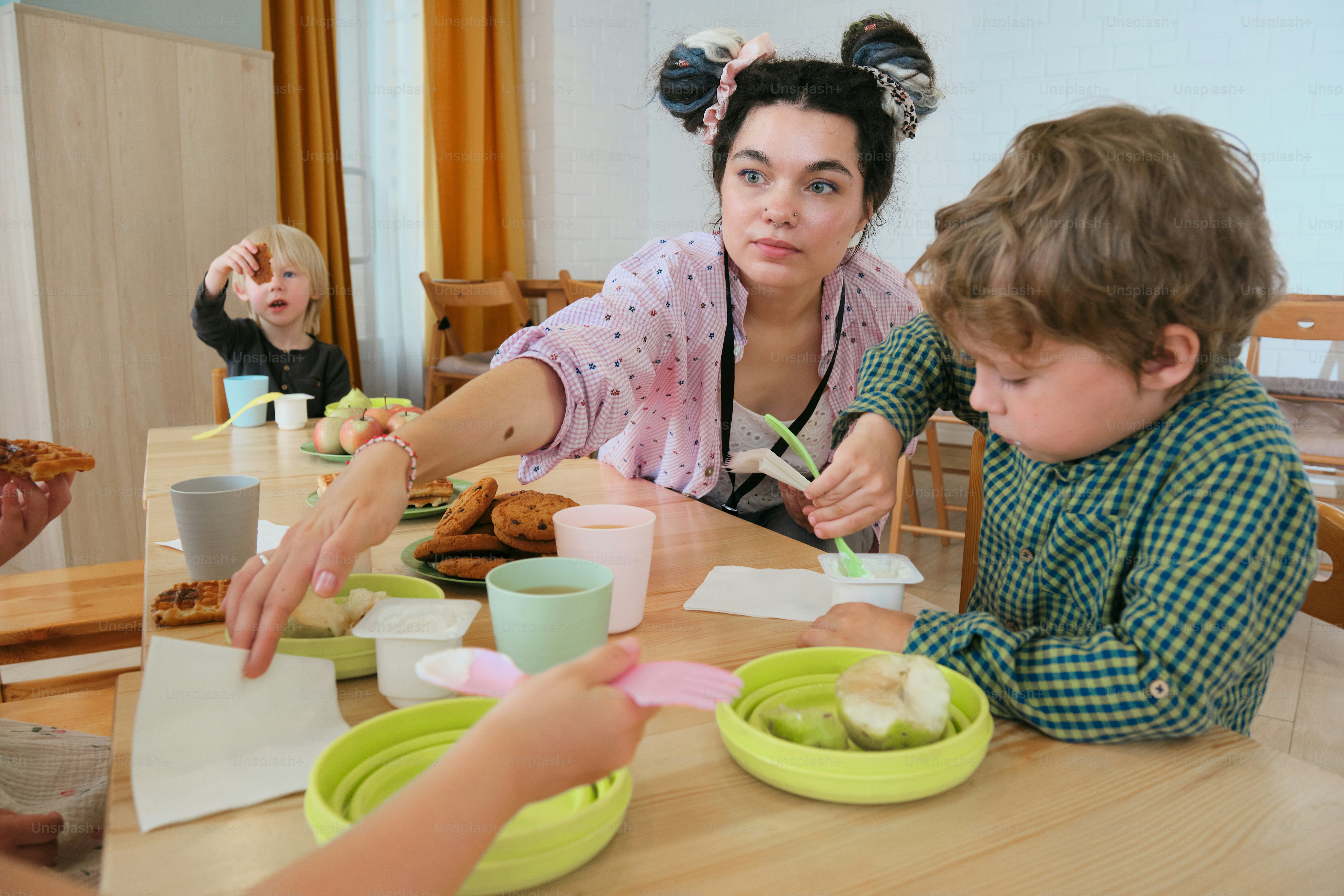 Eine Frau und Kinder essen an einem Tisch.