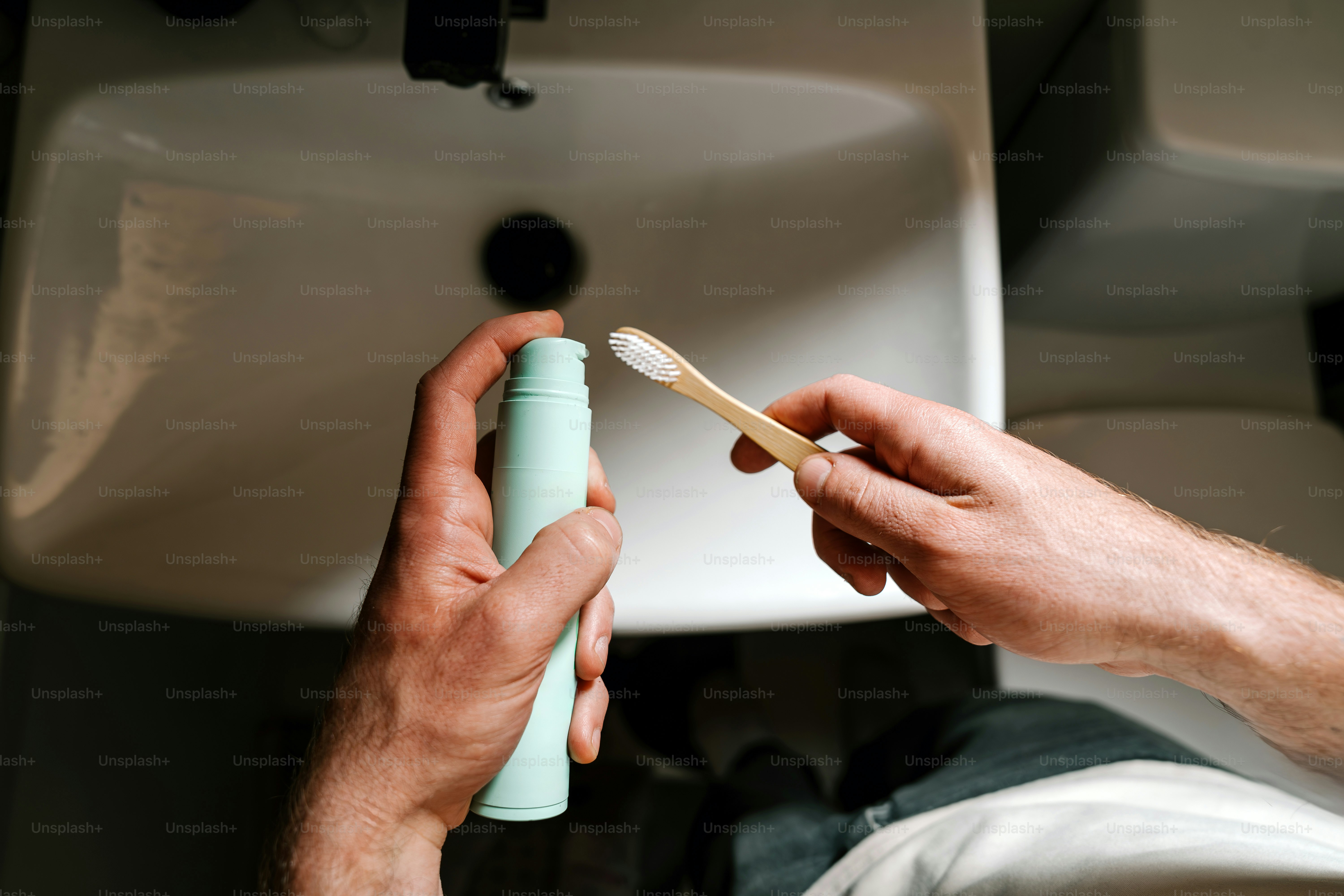 Une personne se prépare à se brosser les dents dans une salle de bain.