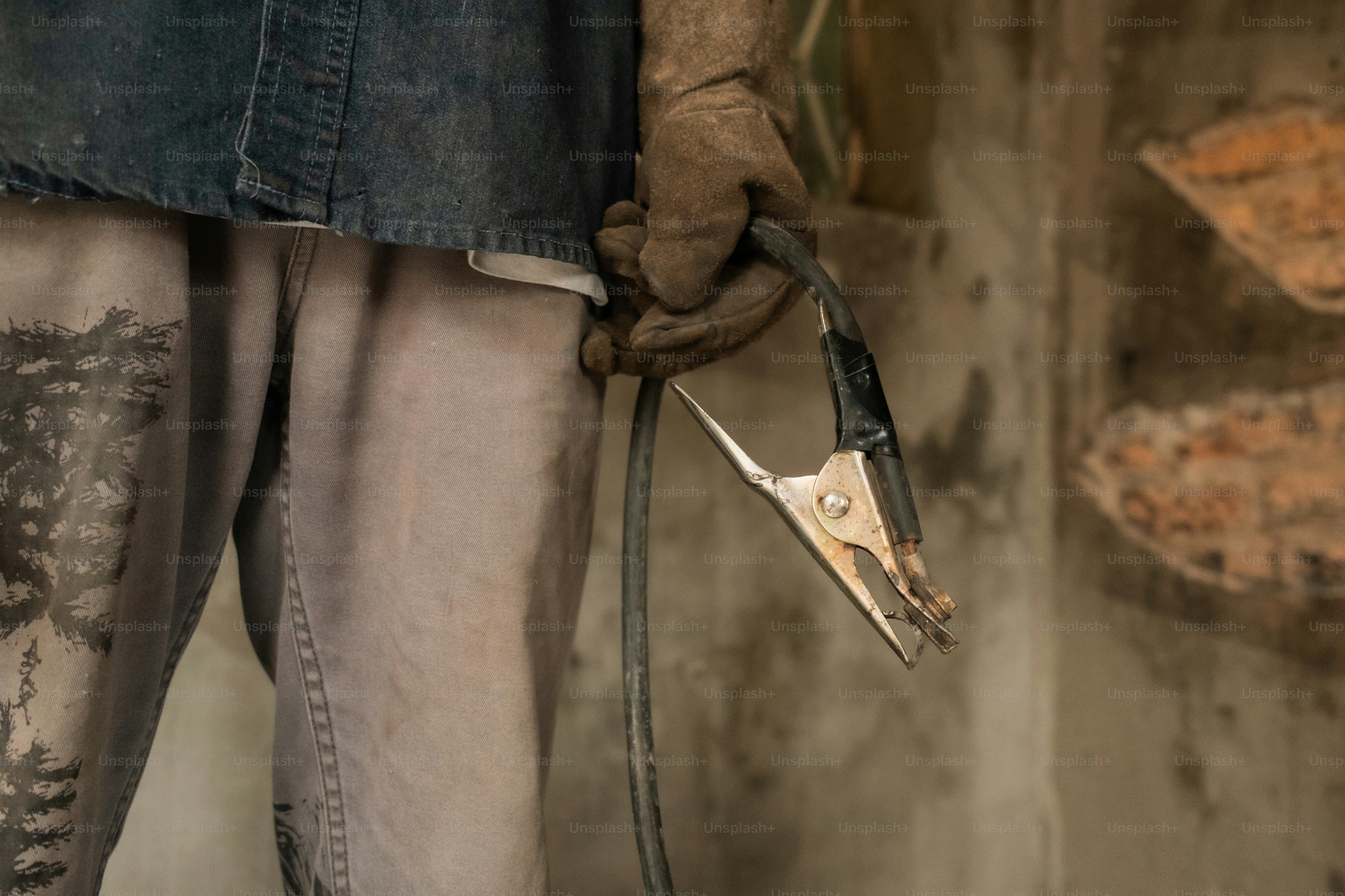 A welder holds a clamp ready for work