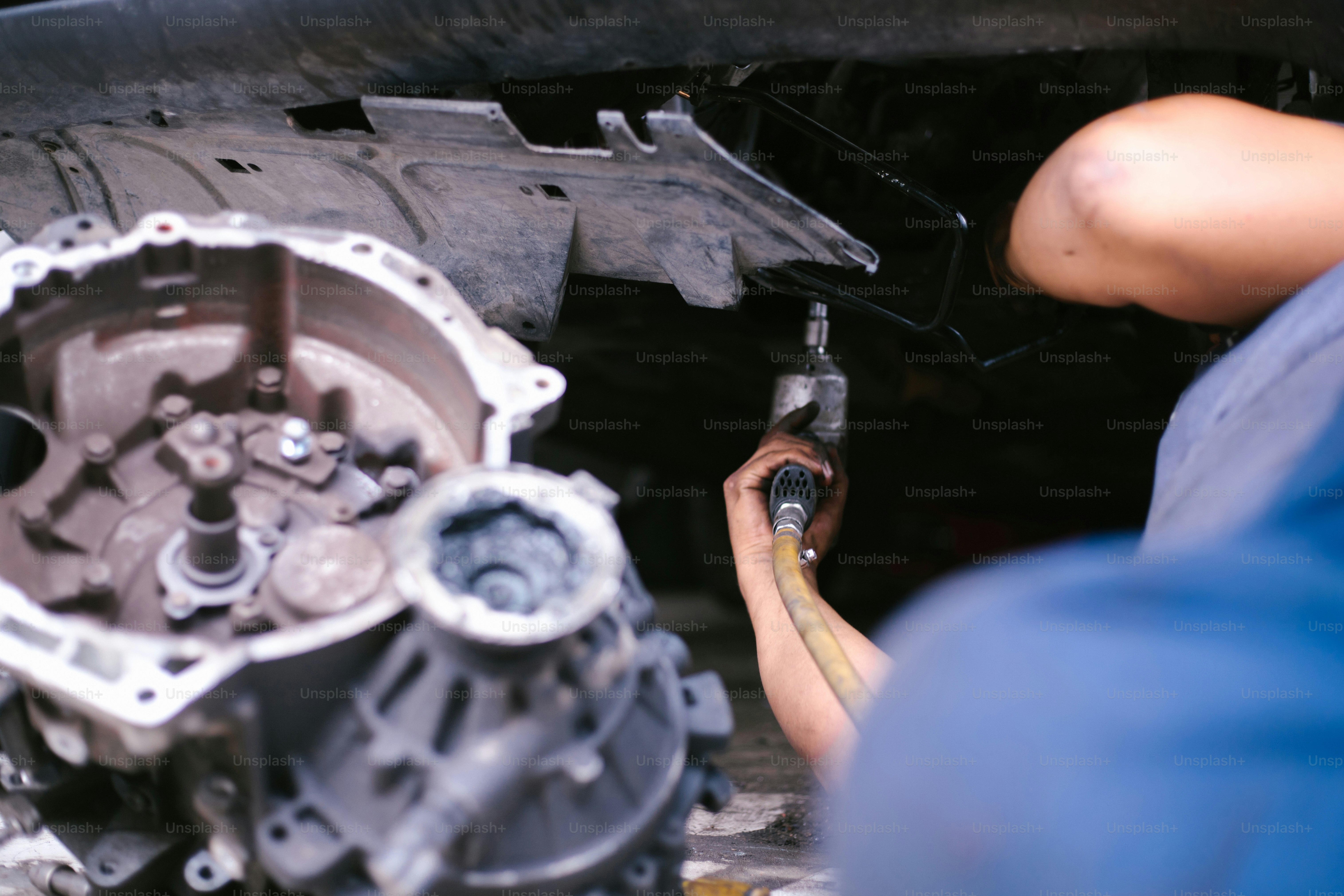 A mechanic is working on a car engine. photo – Worker Image on Unsplash
