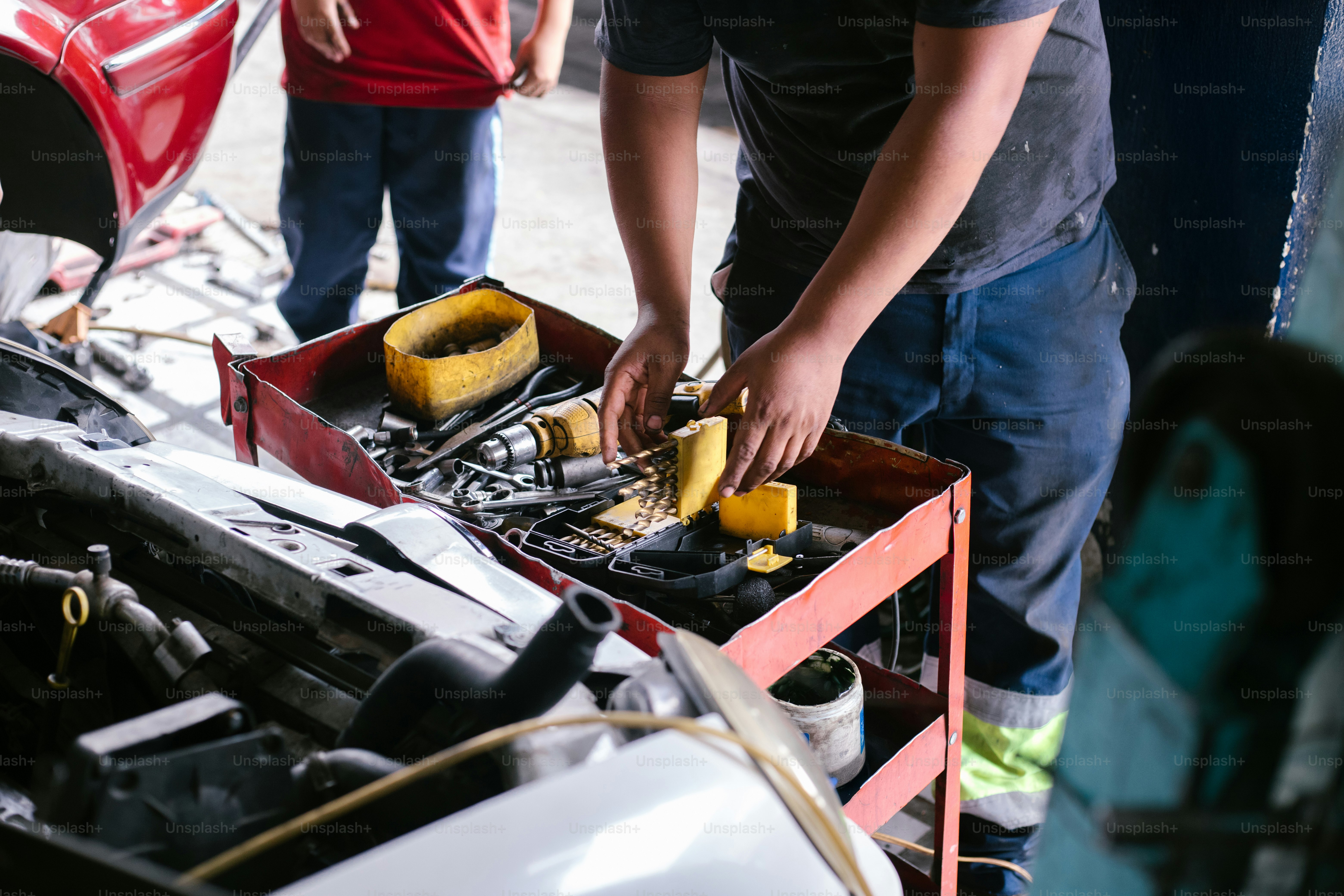 Mechanic is working on a car's engine. photo – Worker Image on Unsplash