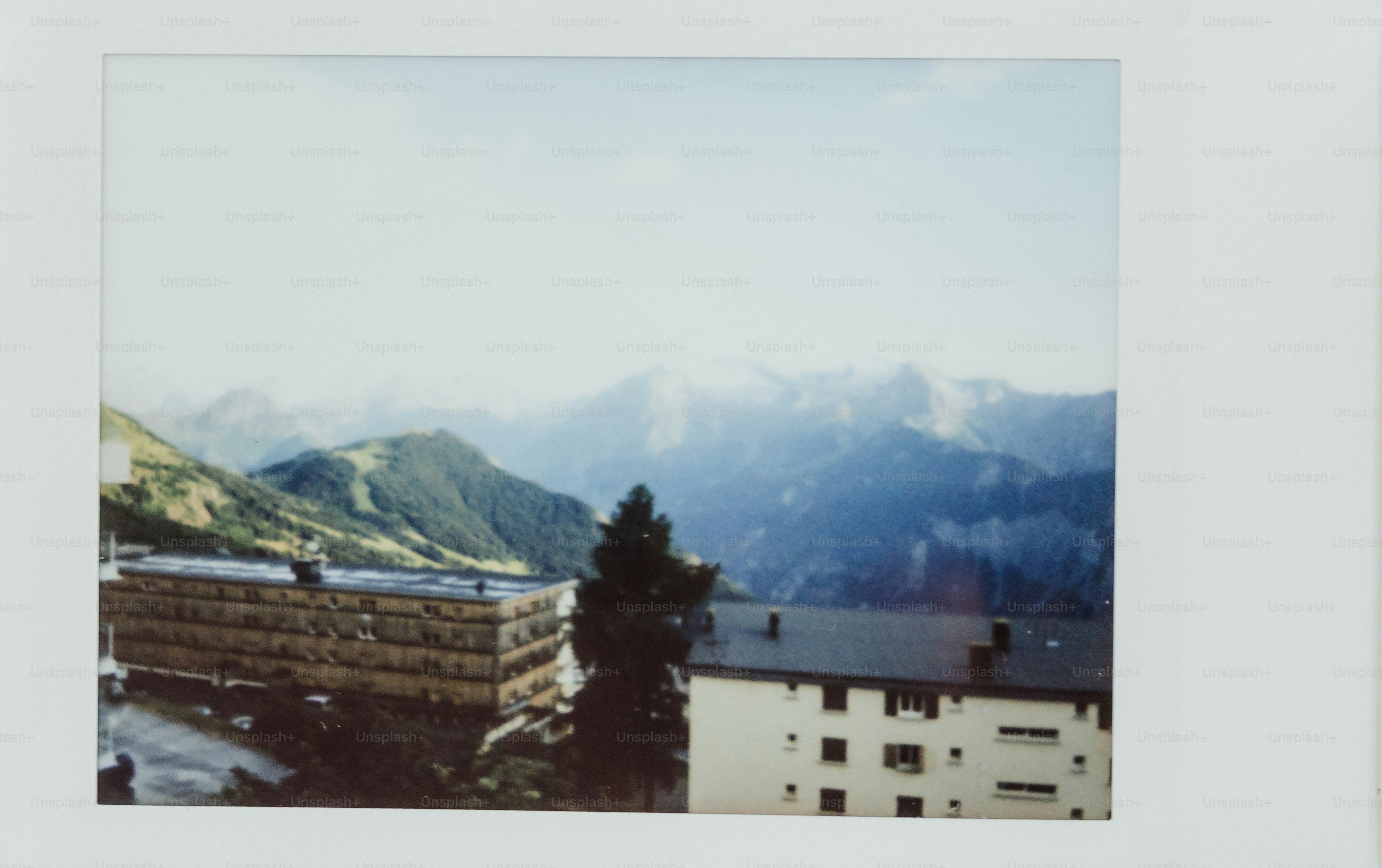 Mountains and buildings under a bright sky.