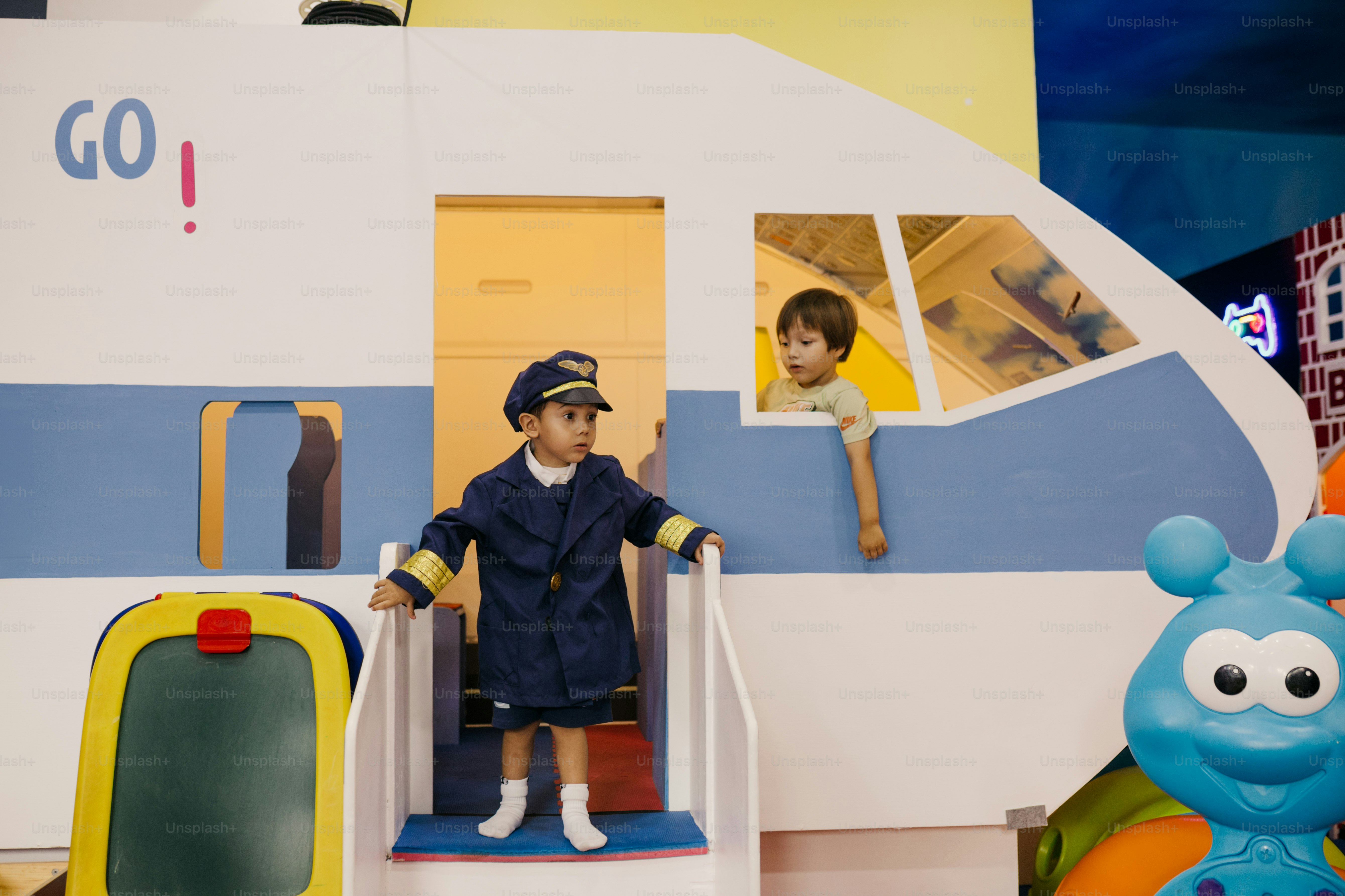 Children are playing in a train-themed play area.