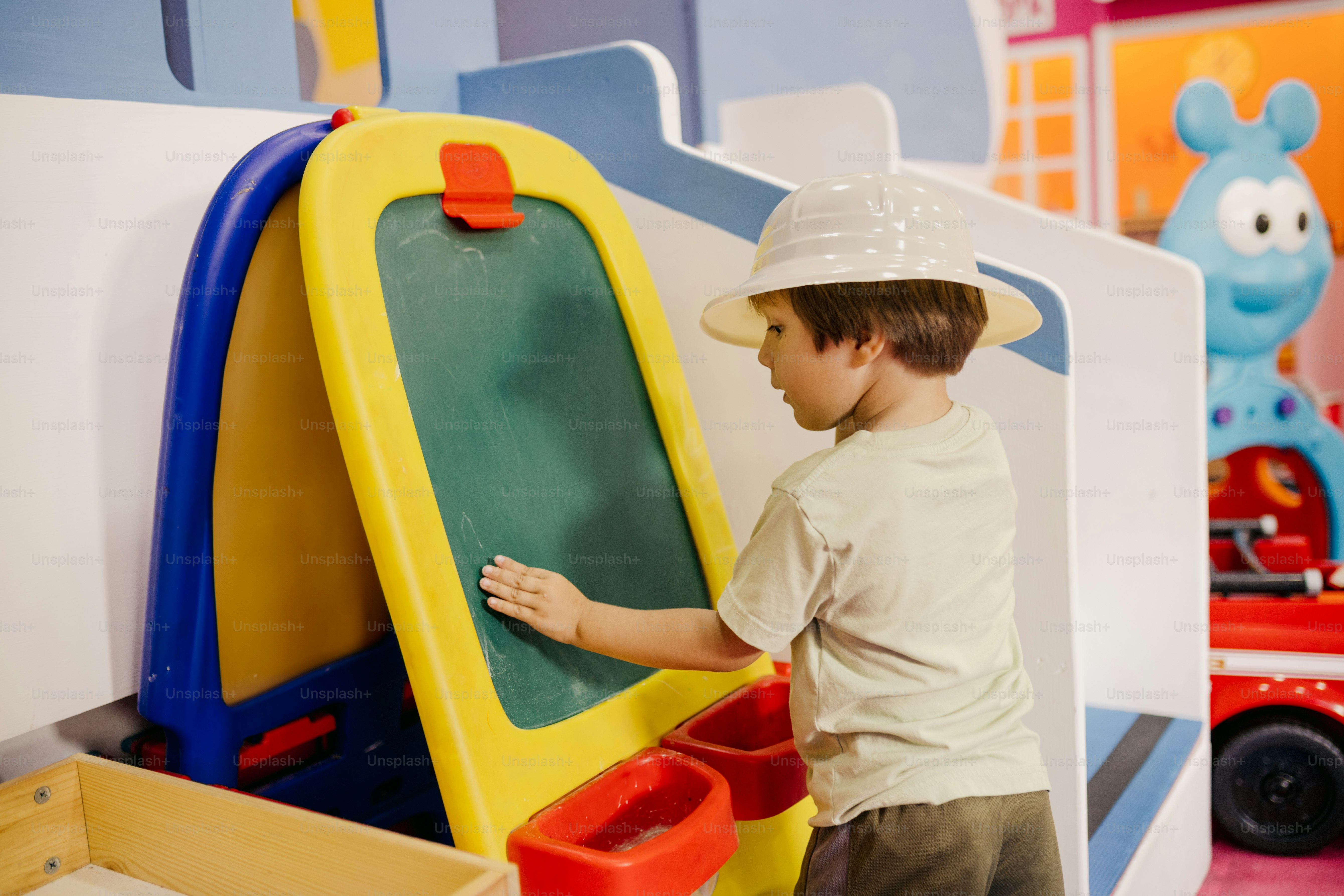 A boy is drawing on an easel.