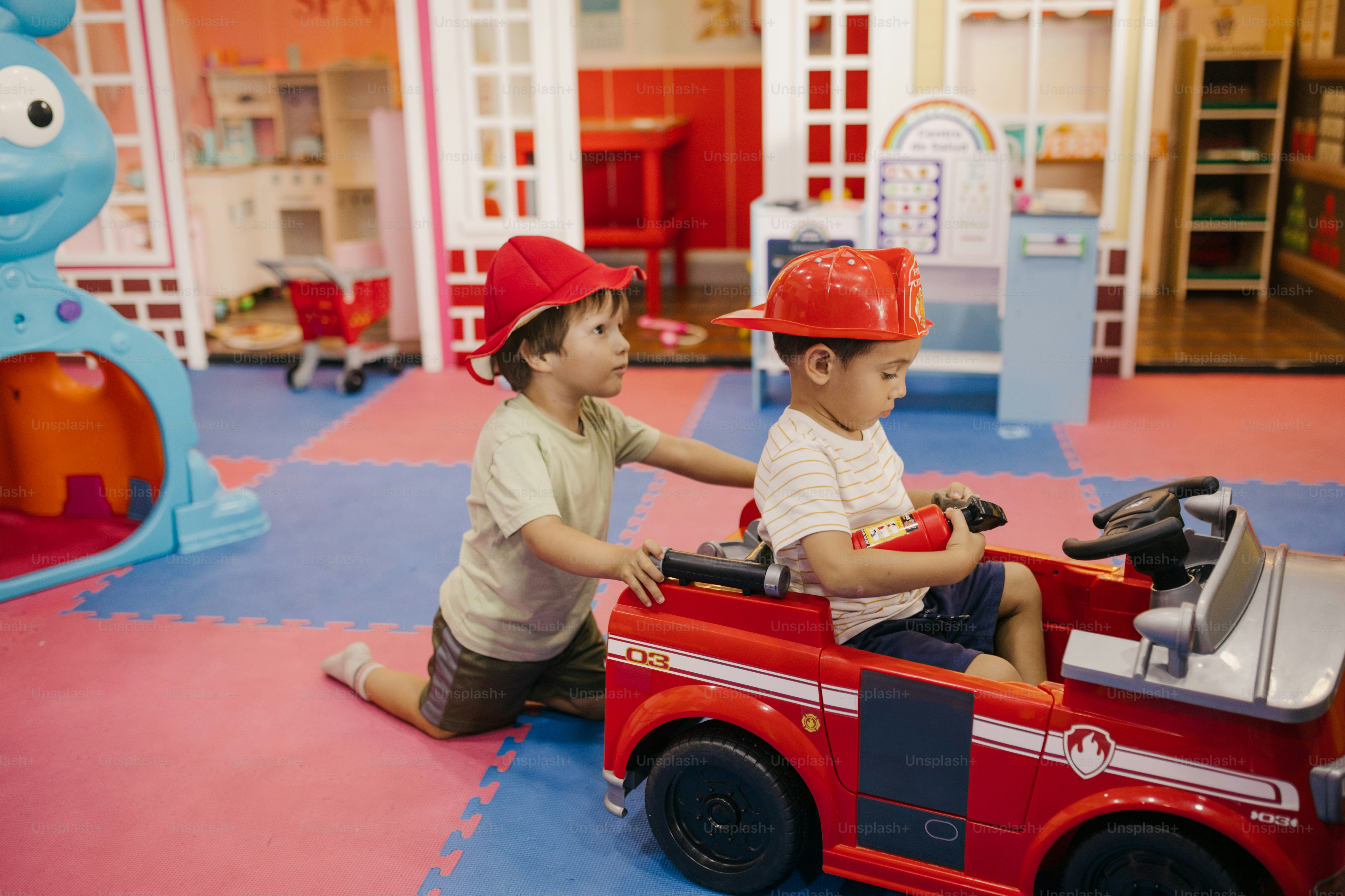 Kids are playing firemen in a playroom.