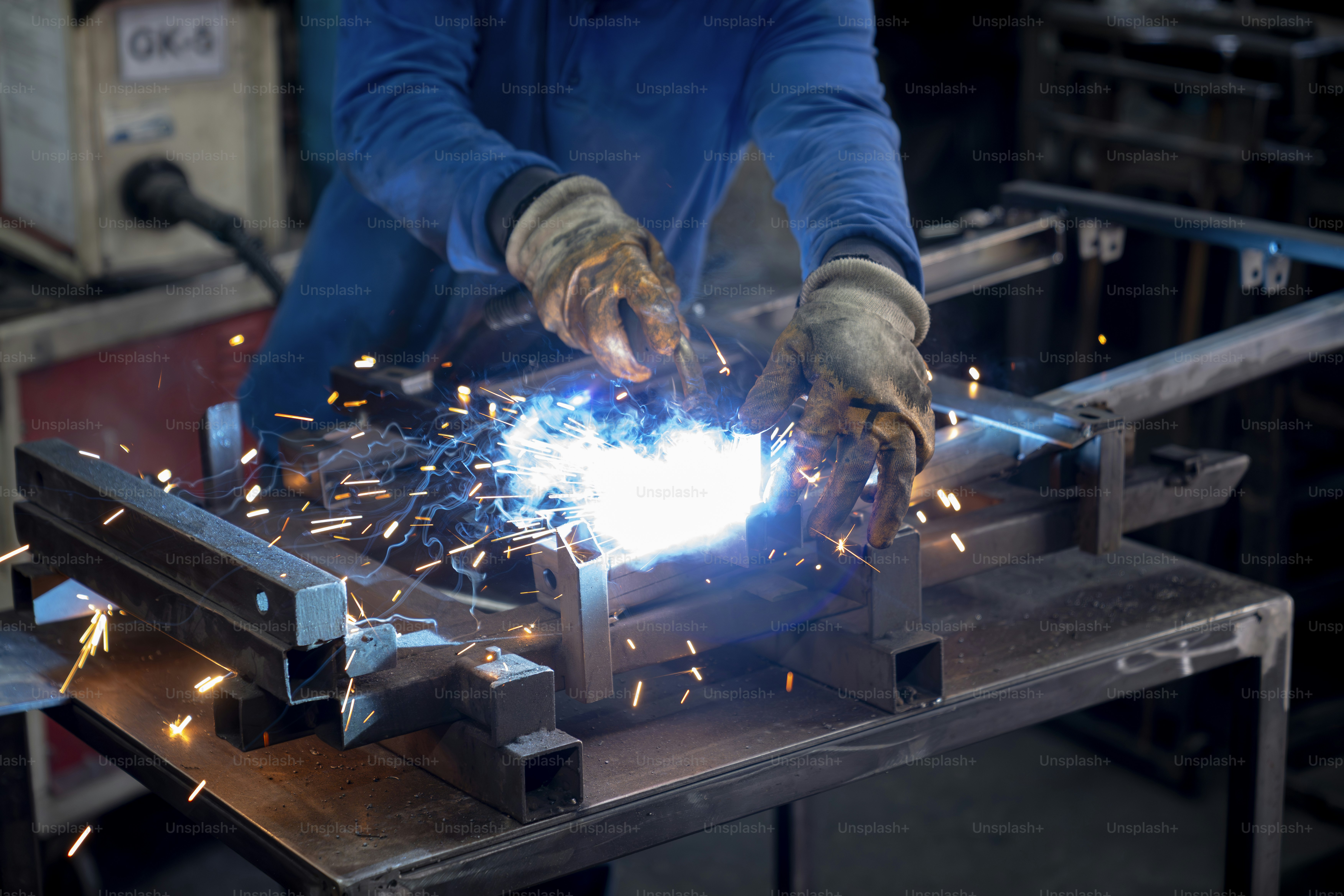 Um soldador está trabalhando com aço.