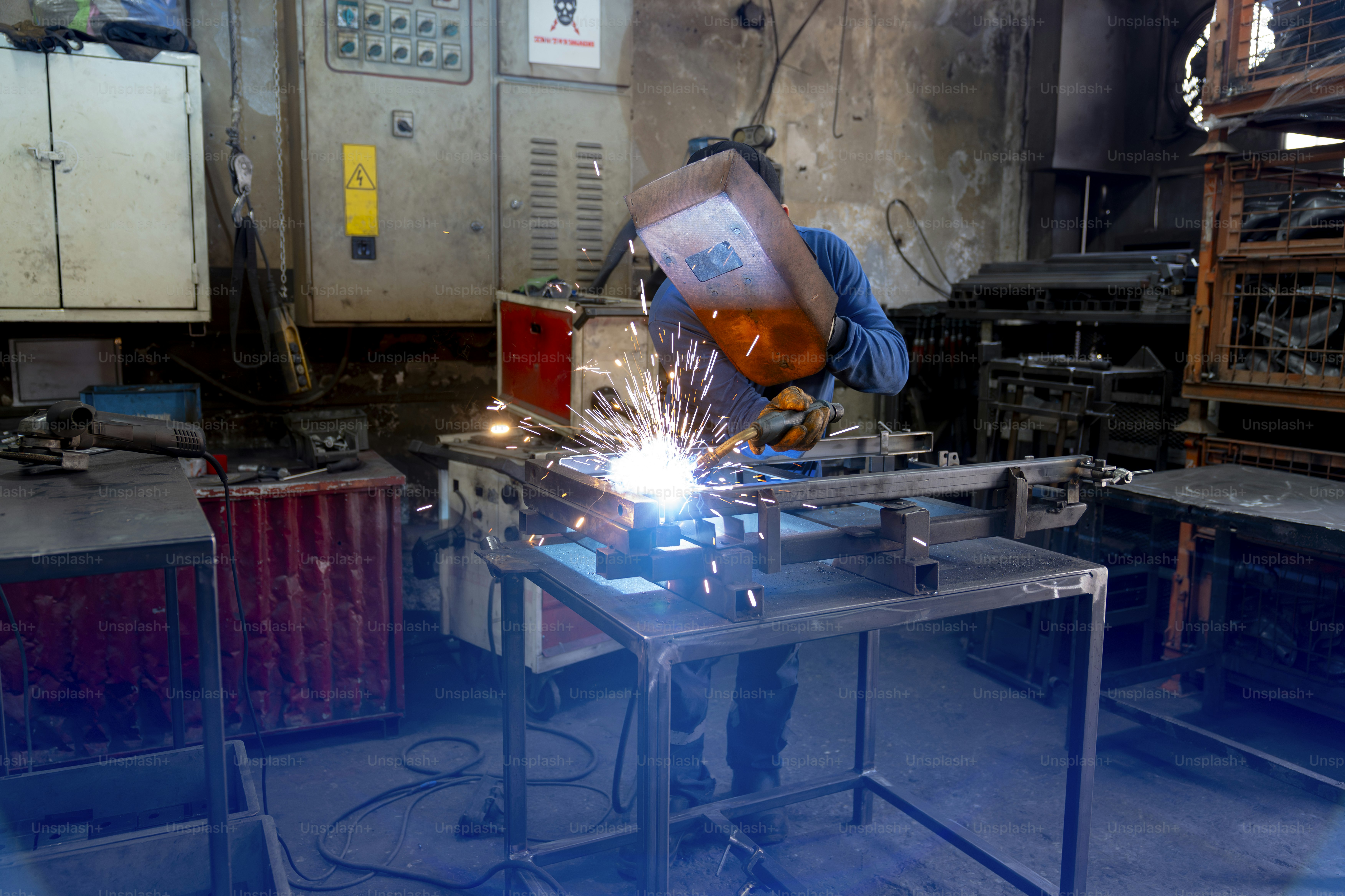 Um soldador está ocupado trabalhando em metal.