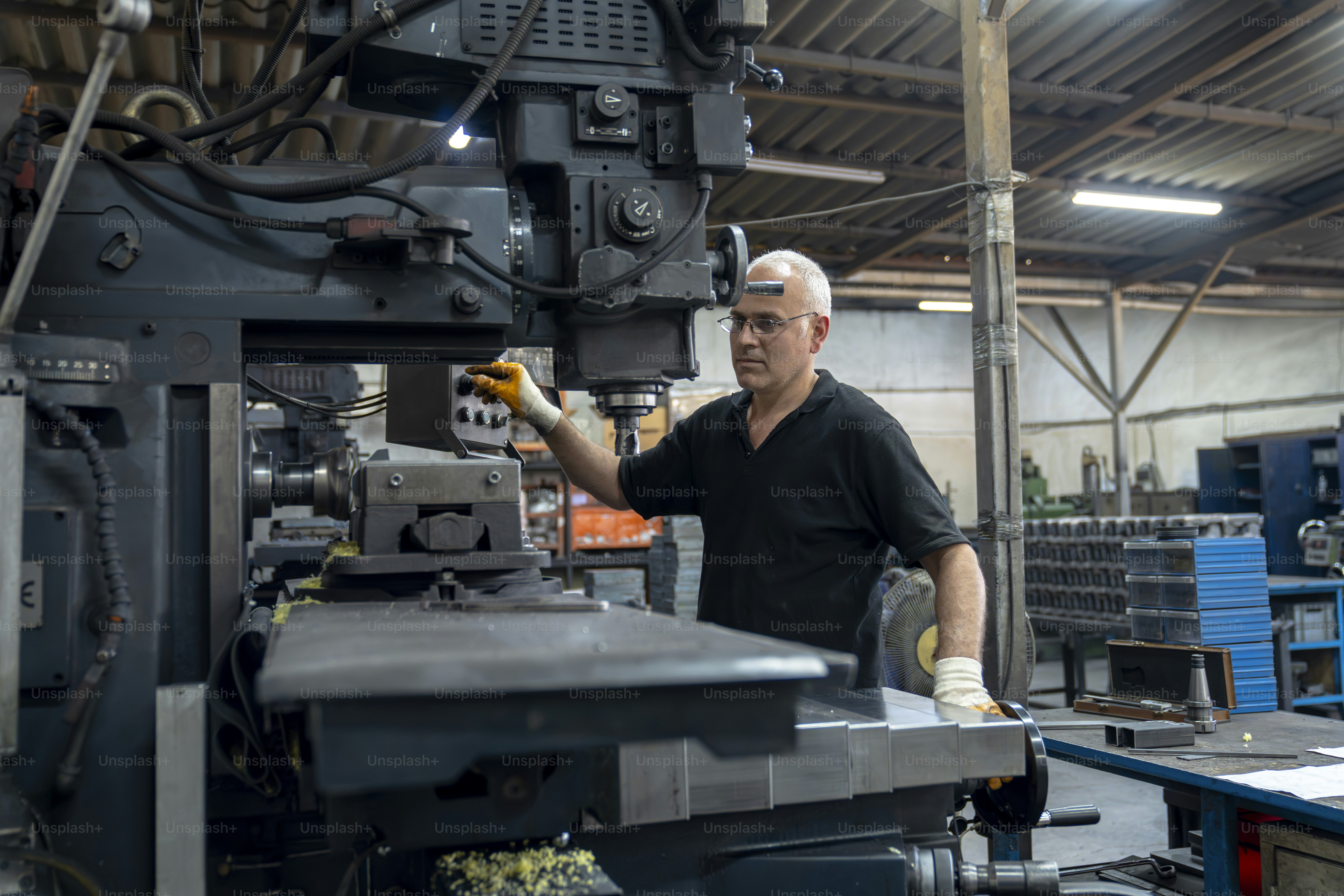 Um homem opera uma fresadora em uma oficina.
