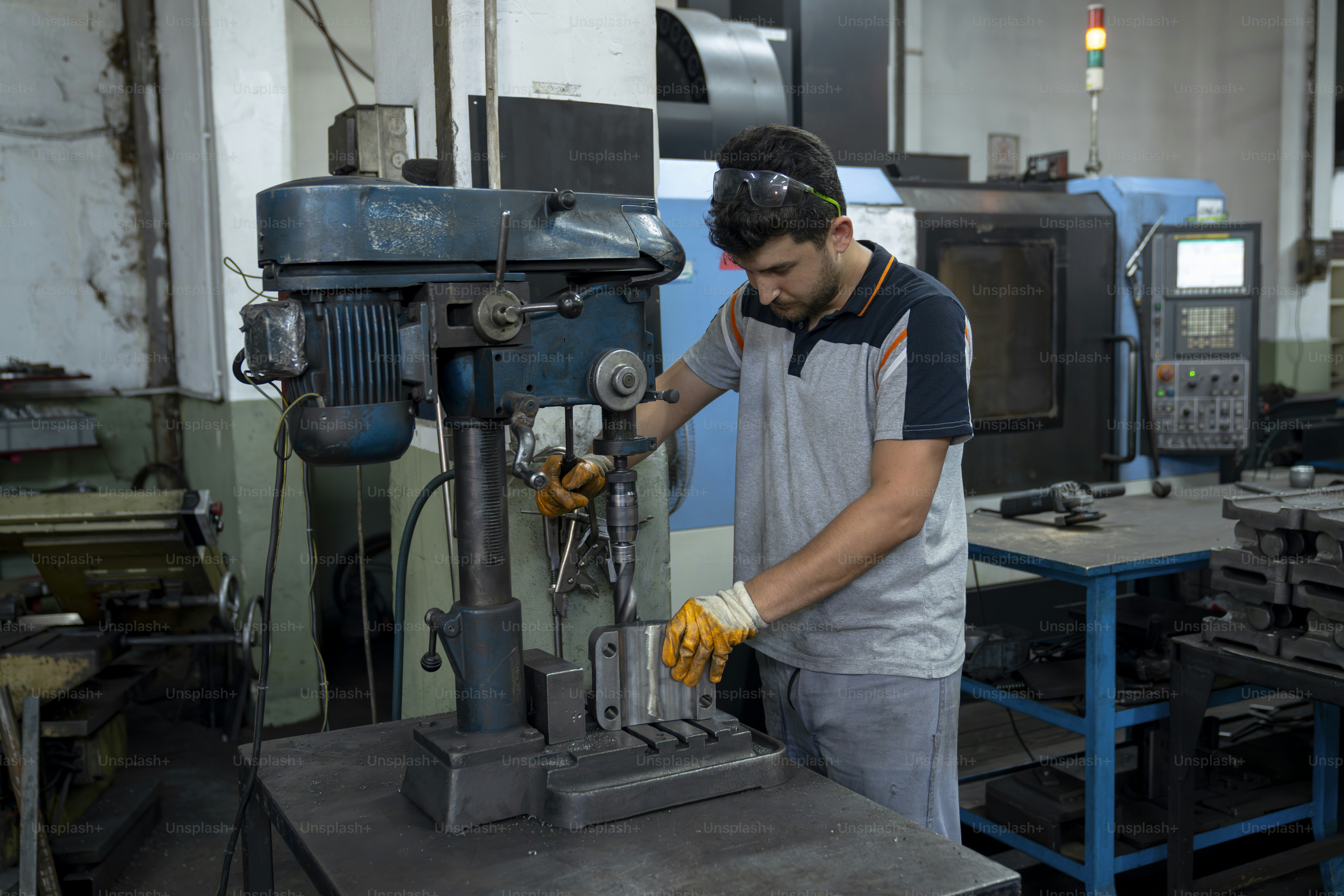 Um homem está operando uma furadeira.