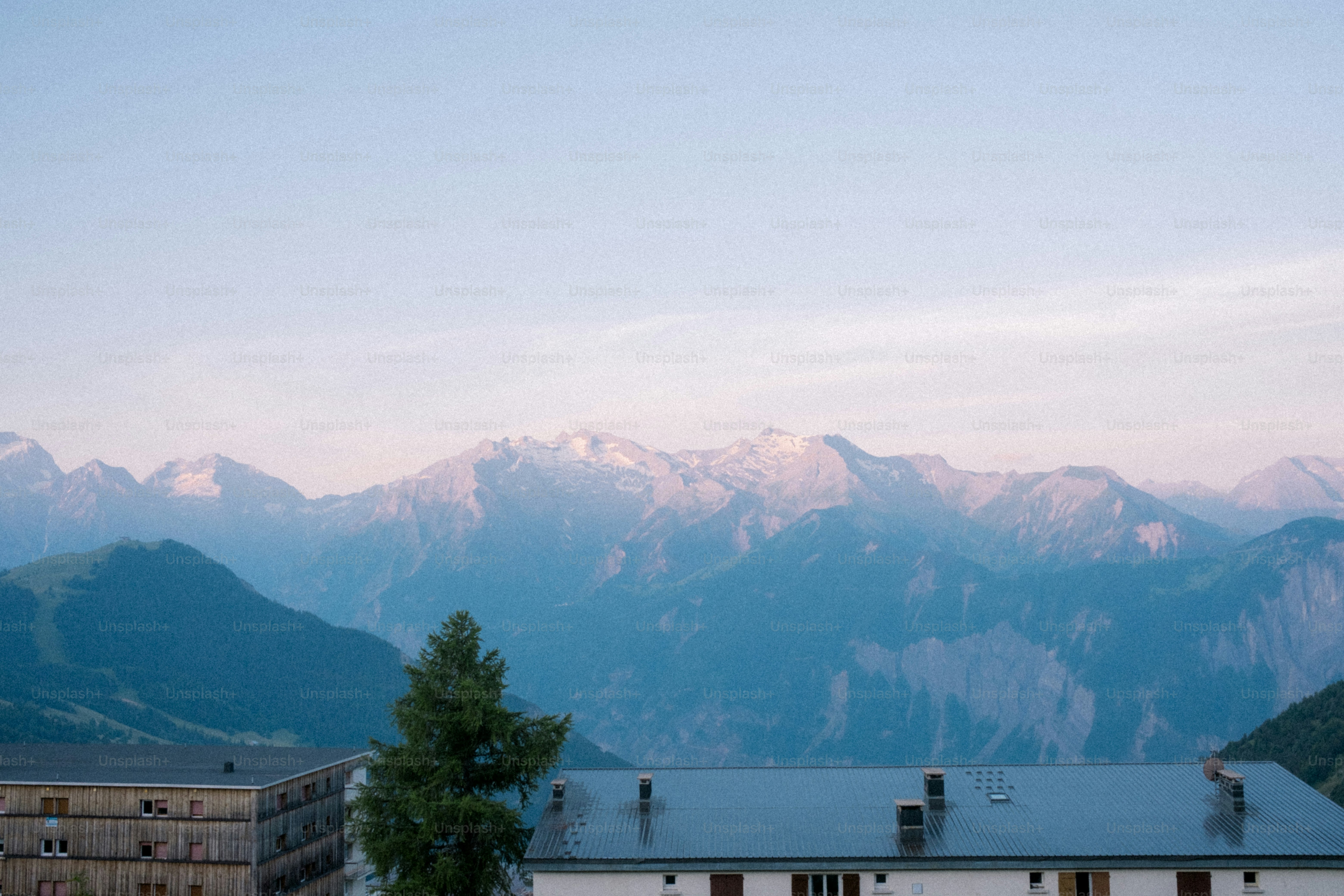 Mountains stand tall beneath a clear, light sky.