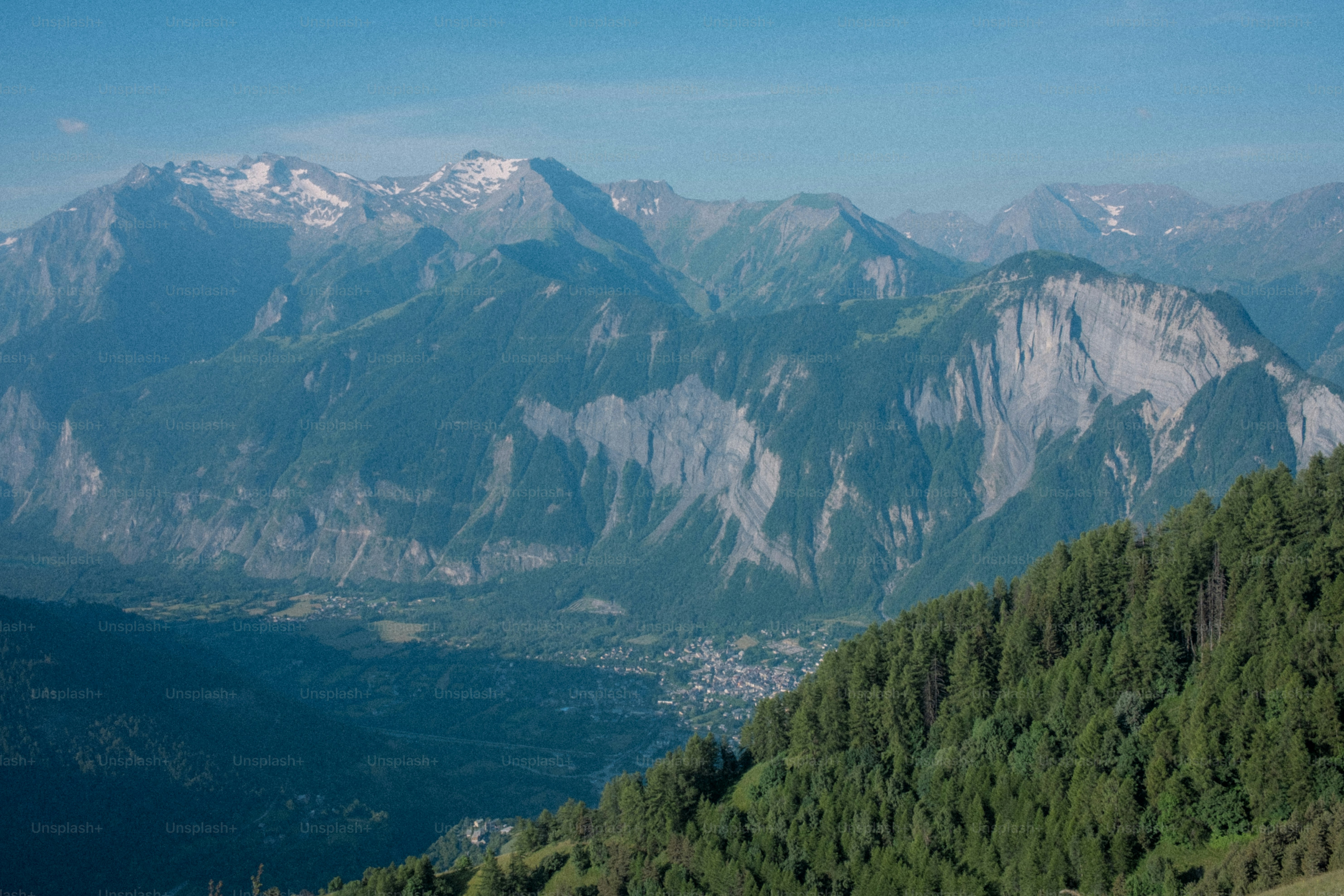 Majestic mountains tower over lush green forest.