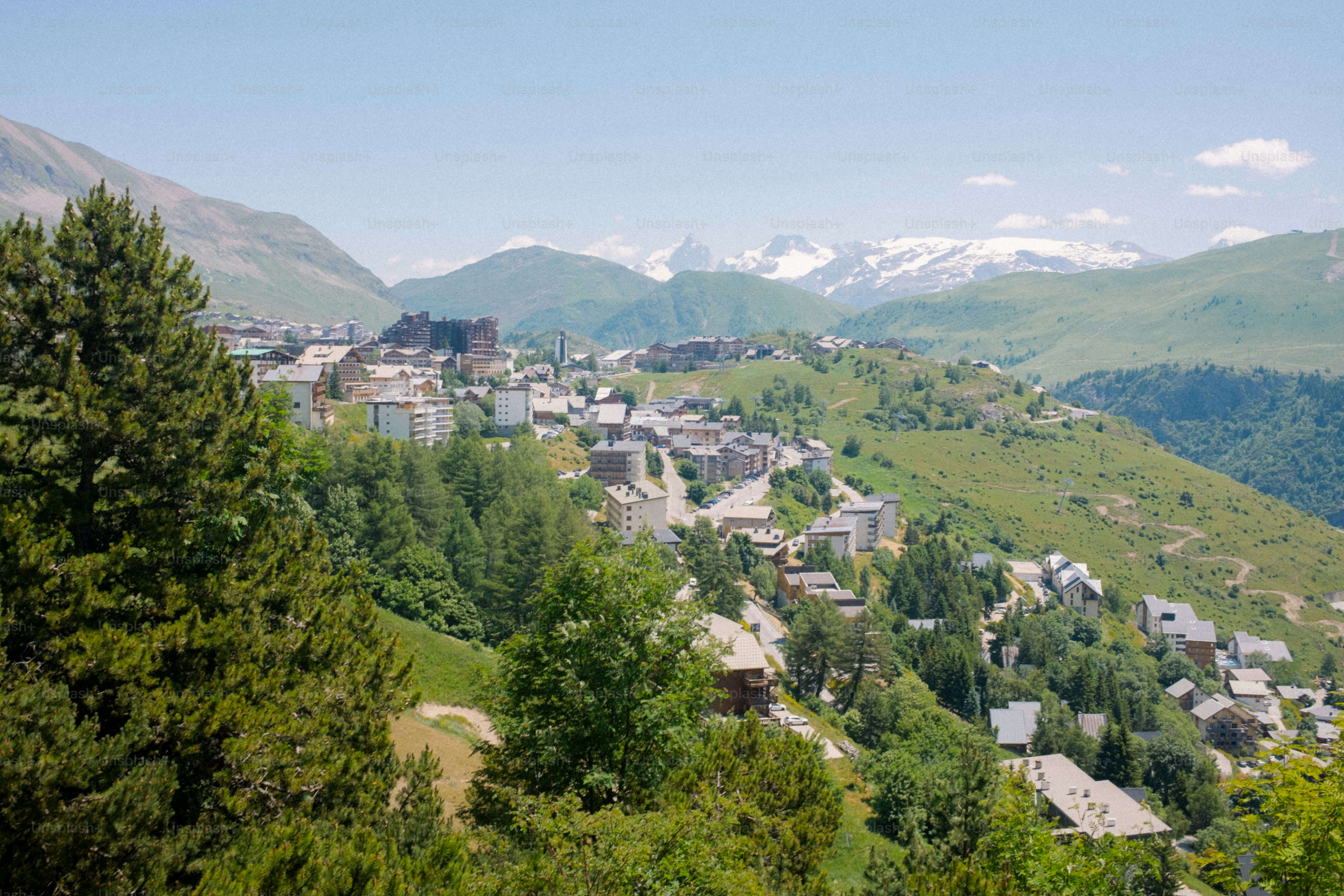 A mountain village with snow-capped peaks in the distance.