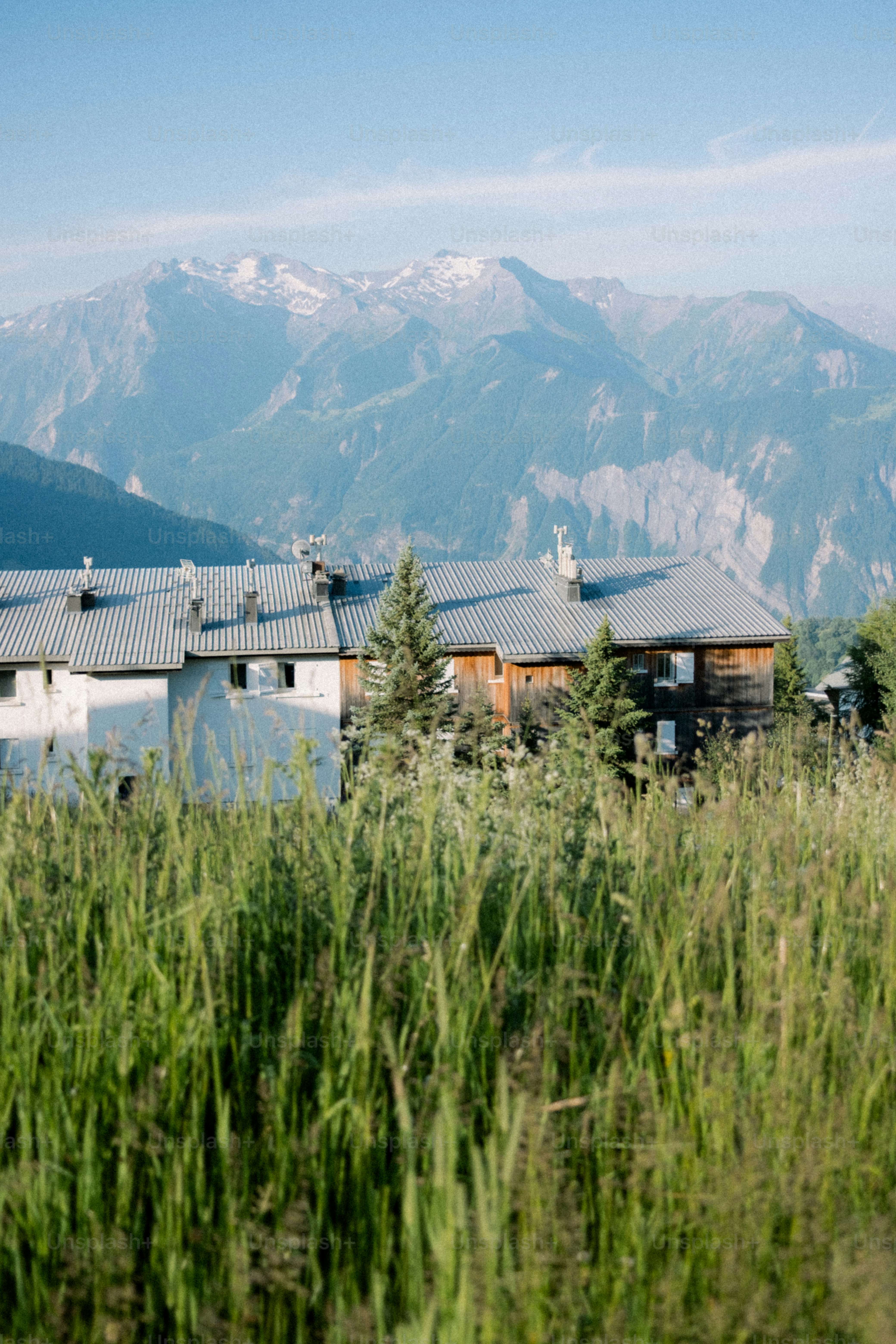 Houses sit below mountains on a sunny day.