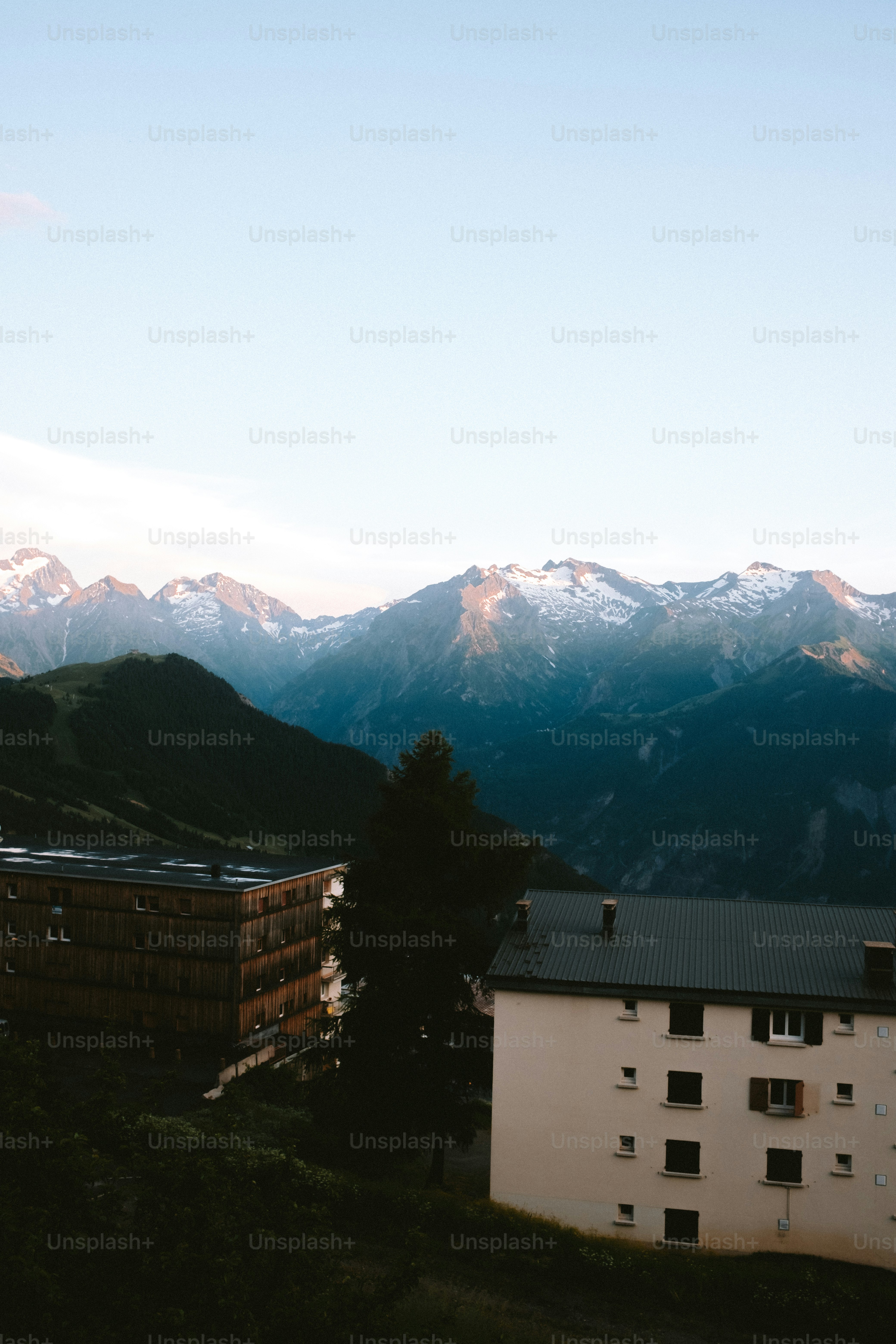 Mountains tower over buildings at sunset.