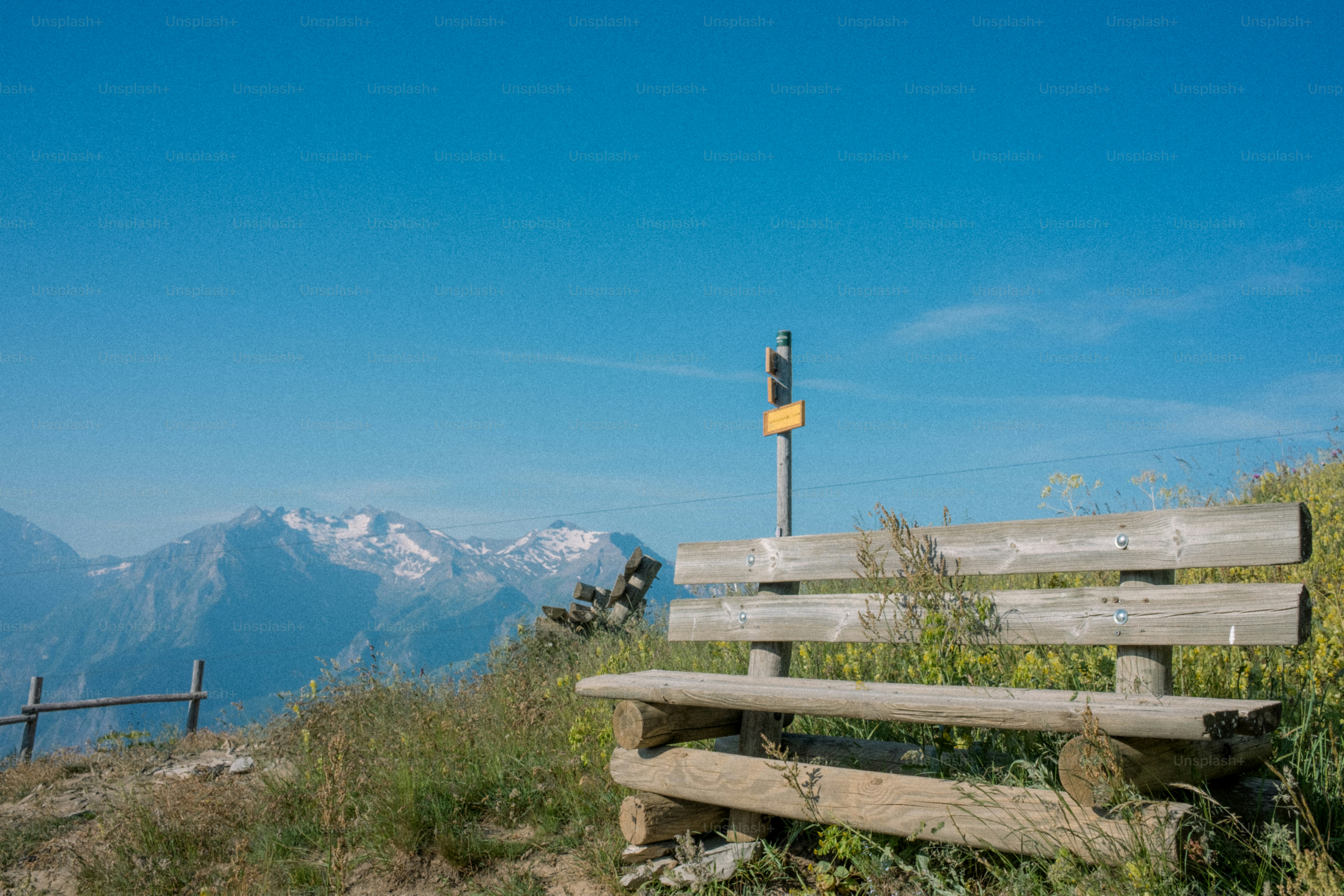 A wooden bench sits overlooking scenic mountains.