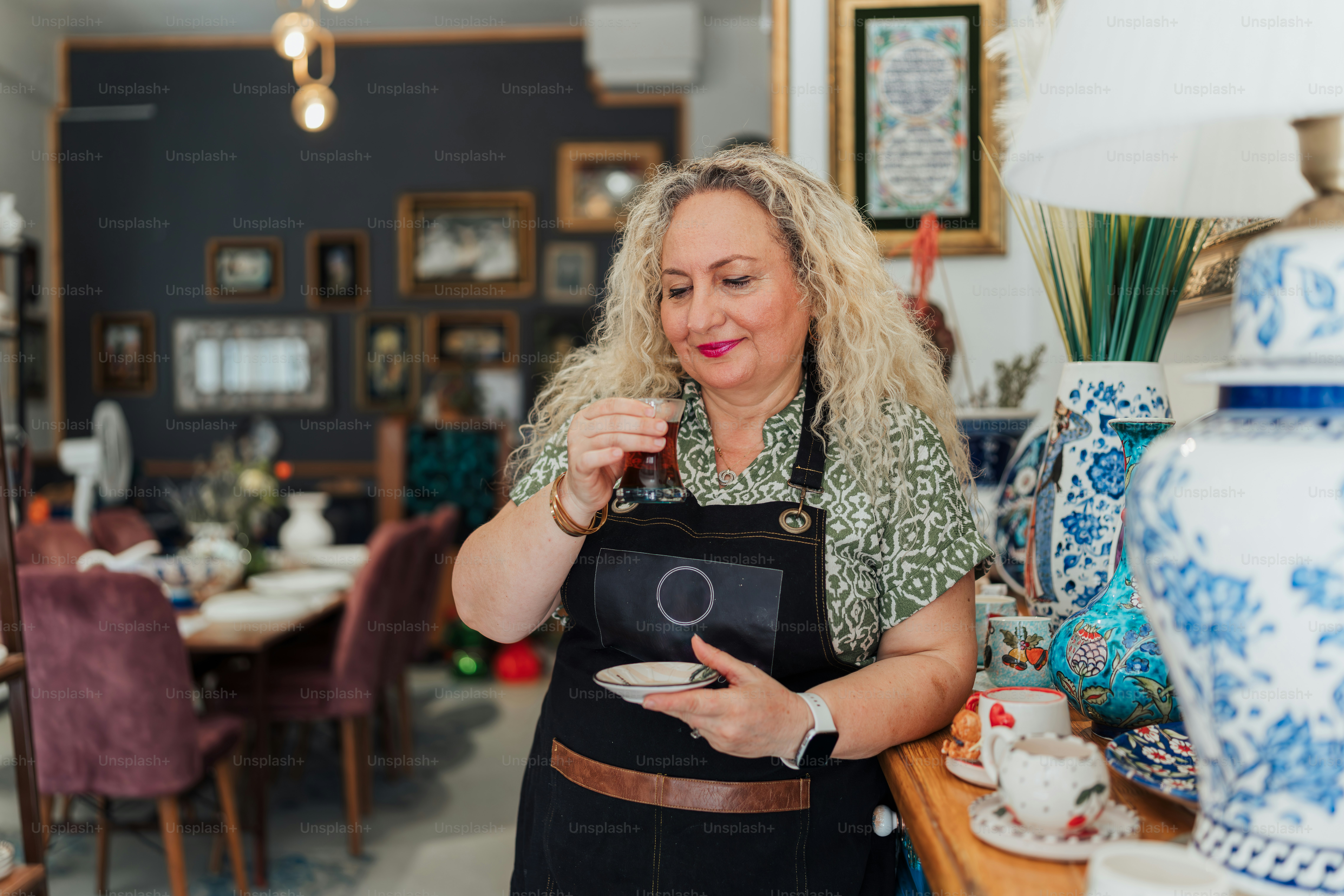 Woman sips tea in a beautiful shop.