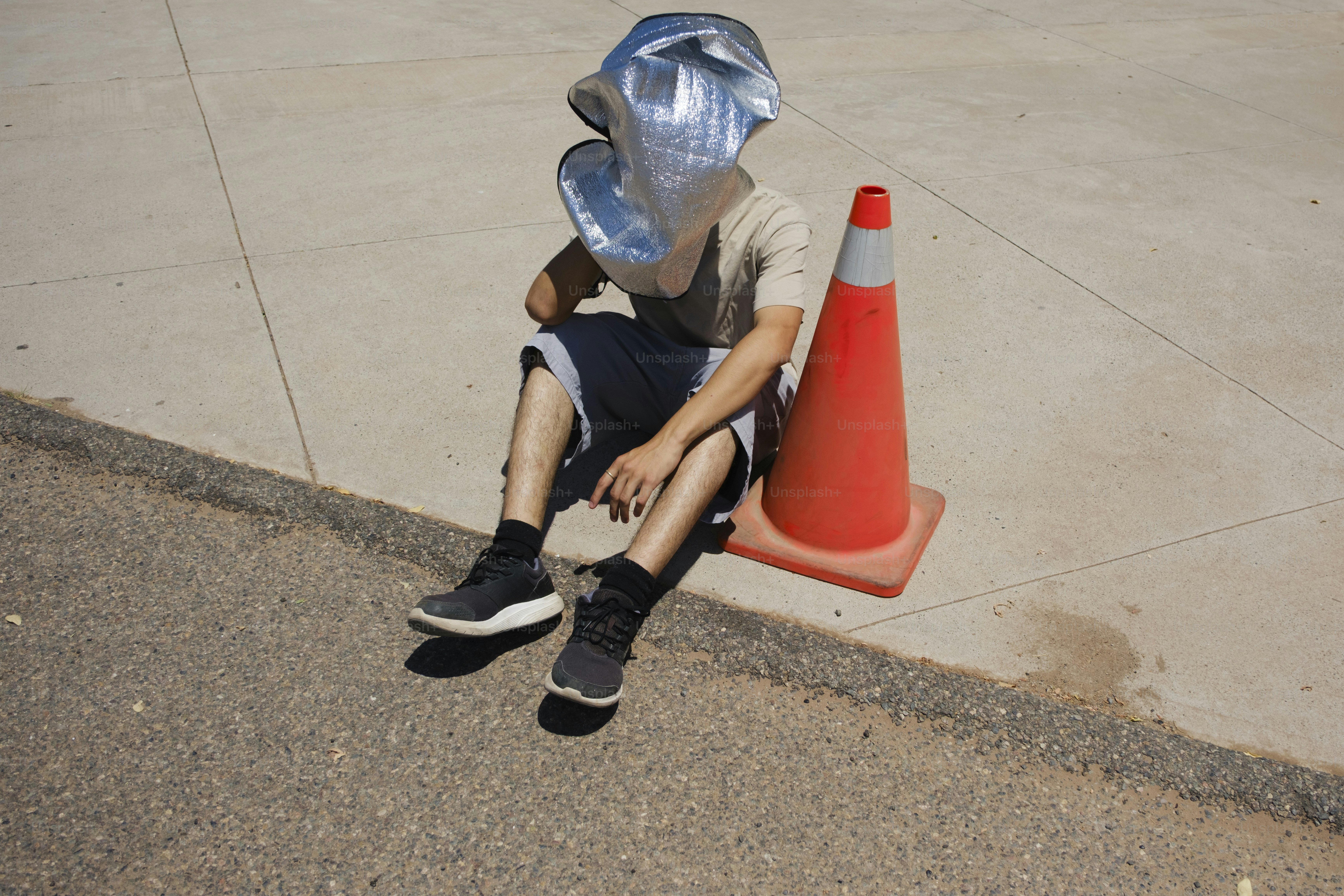 ホイルヘッドを持つ人はコーンの近くに座っています。