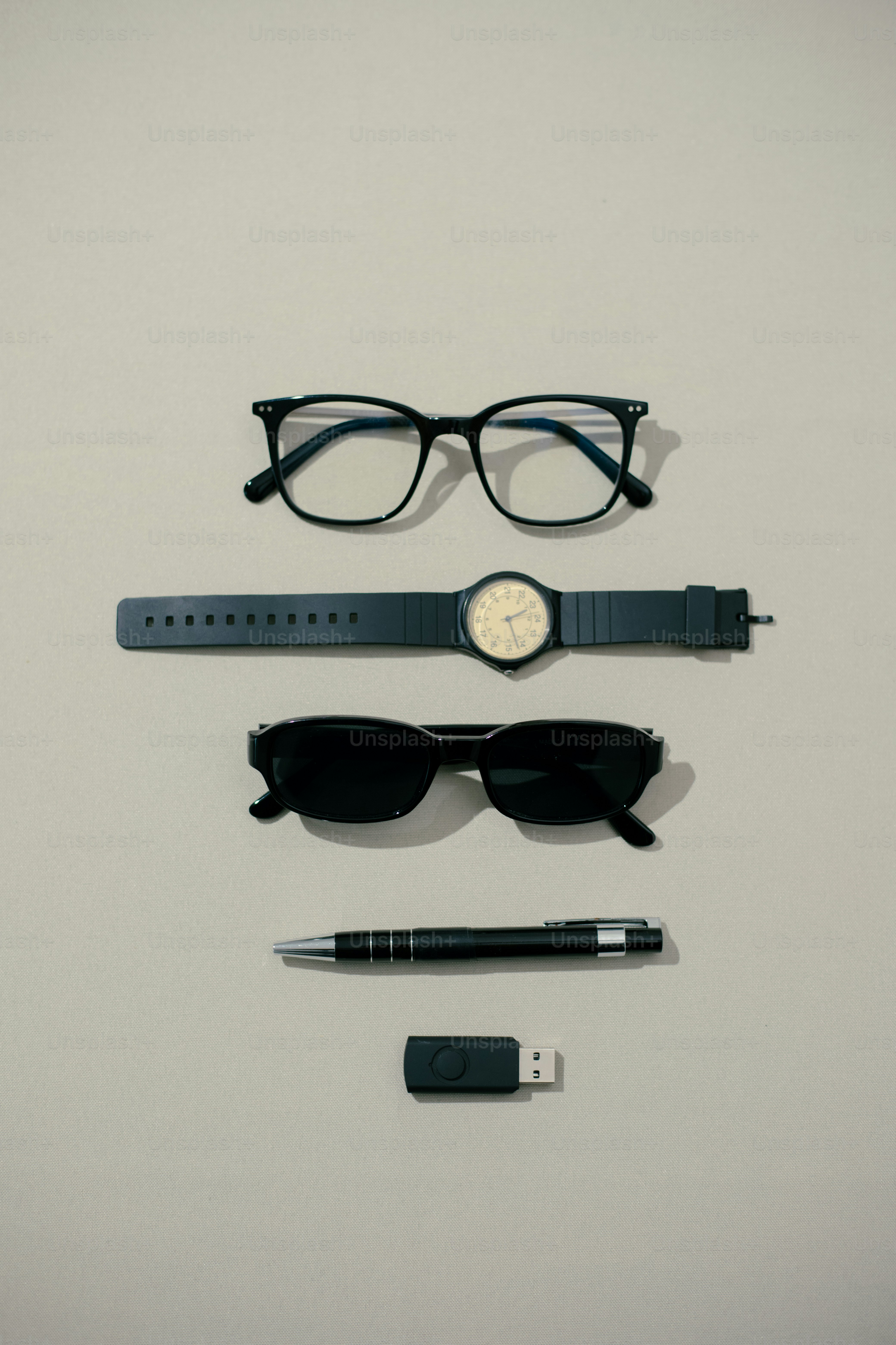 Accessories including glasses, a watch and a pen.