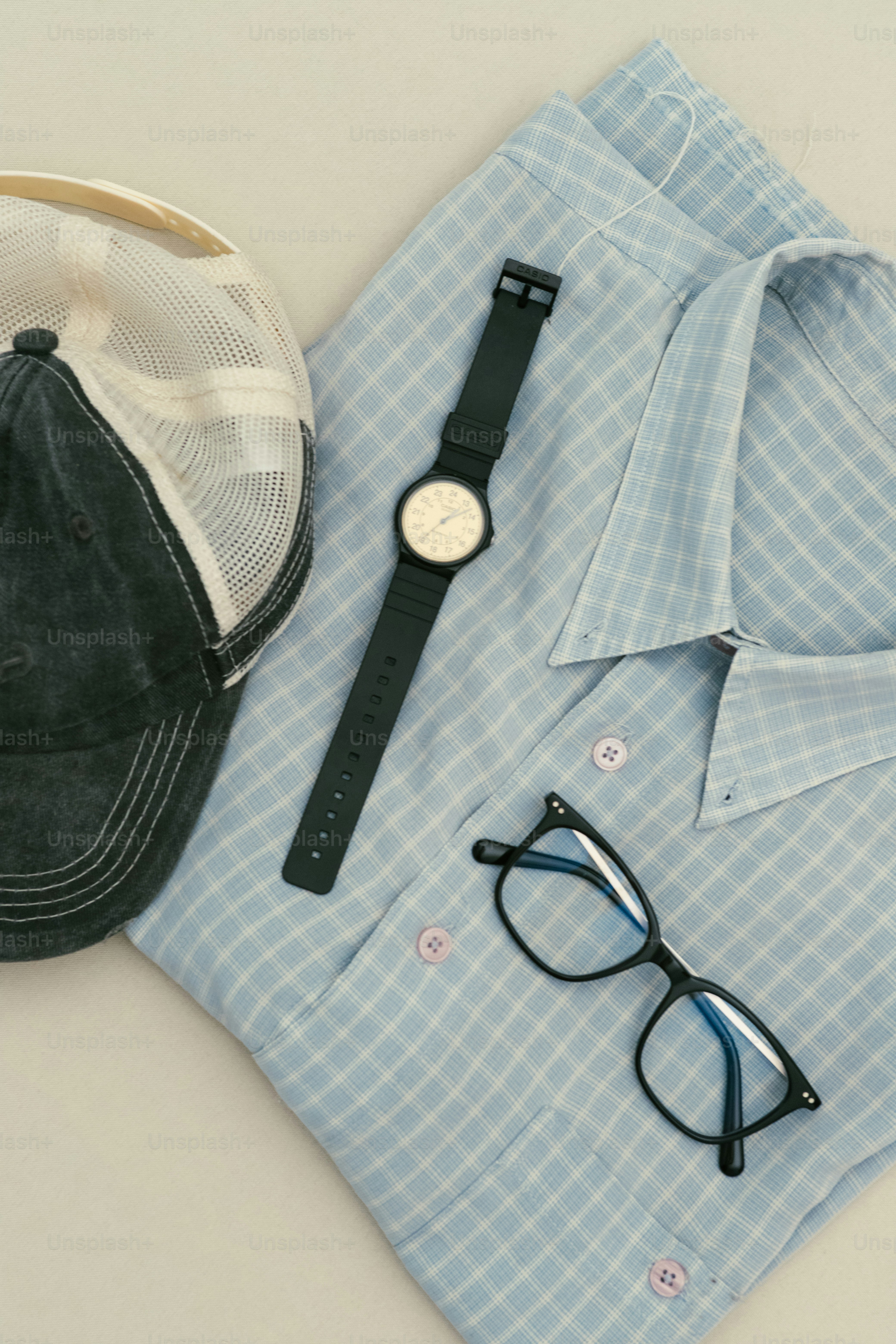 Abbigliamento casual: camicia, orologio, occhiali e cappello.